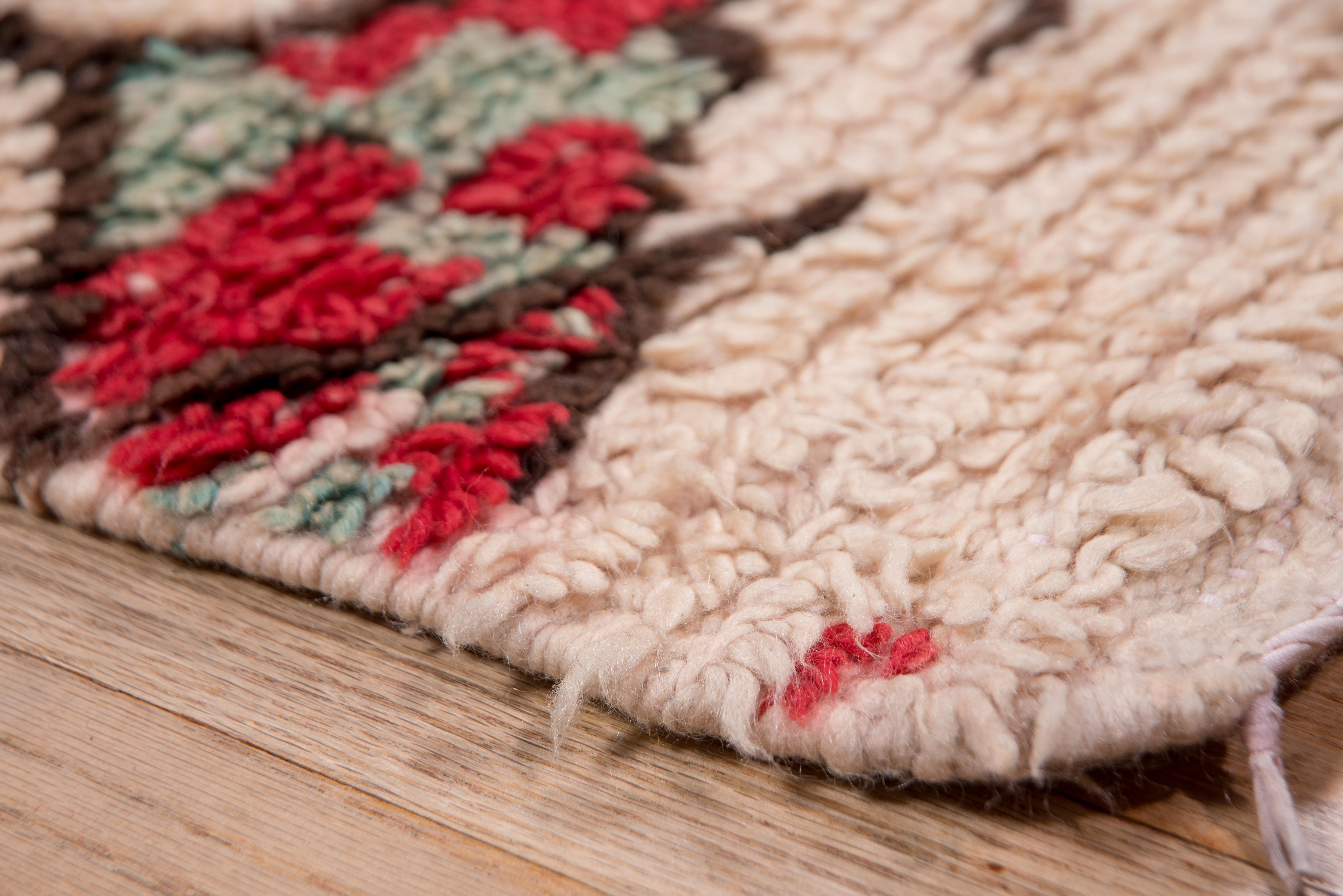 This diamond allover rug is 100% wool and features ivory, dark red, and black accents. 