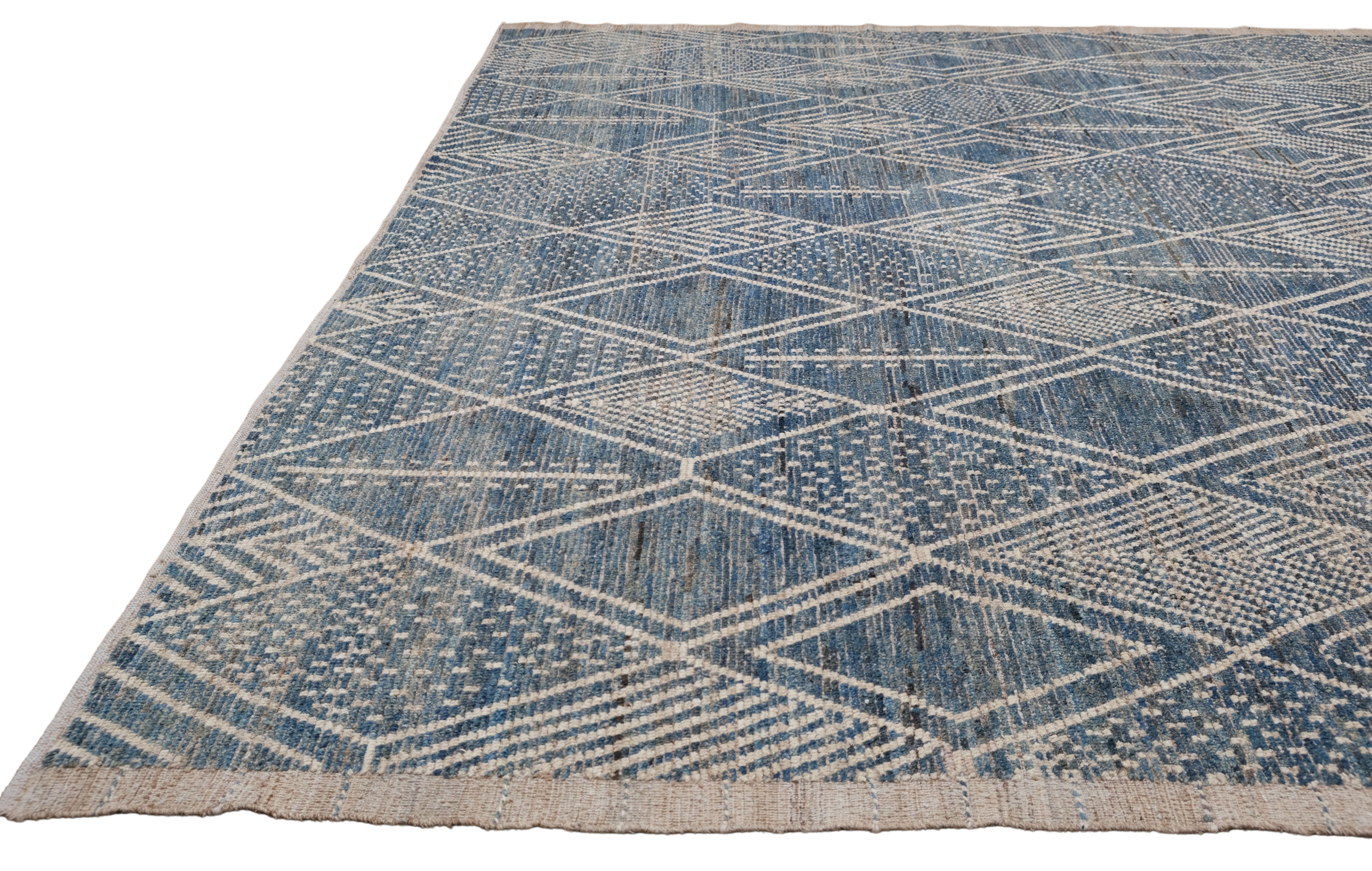 This stunning hand-knotted wool rug features a contemporary take on geometric patterns, seamlessly blending tradition and modernity. Measuring an impressive 12'3