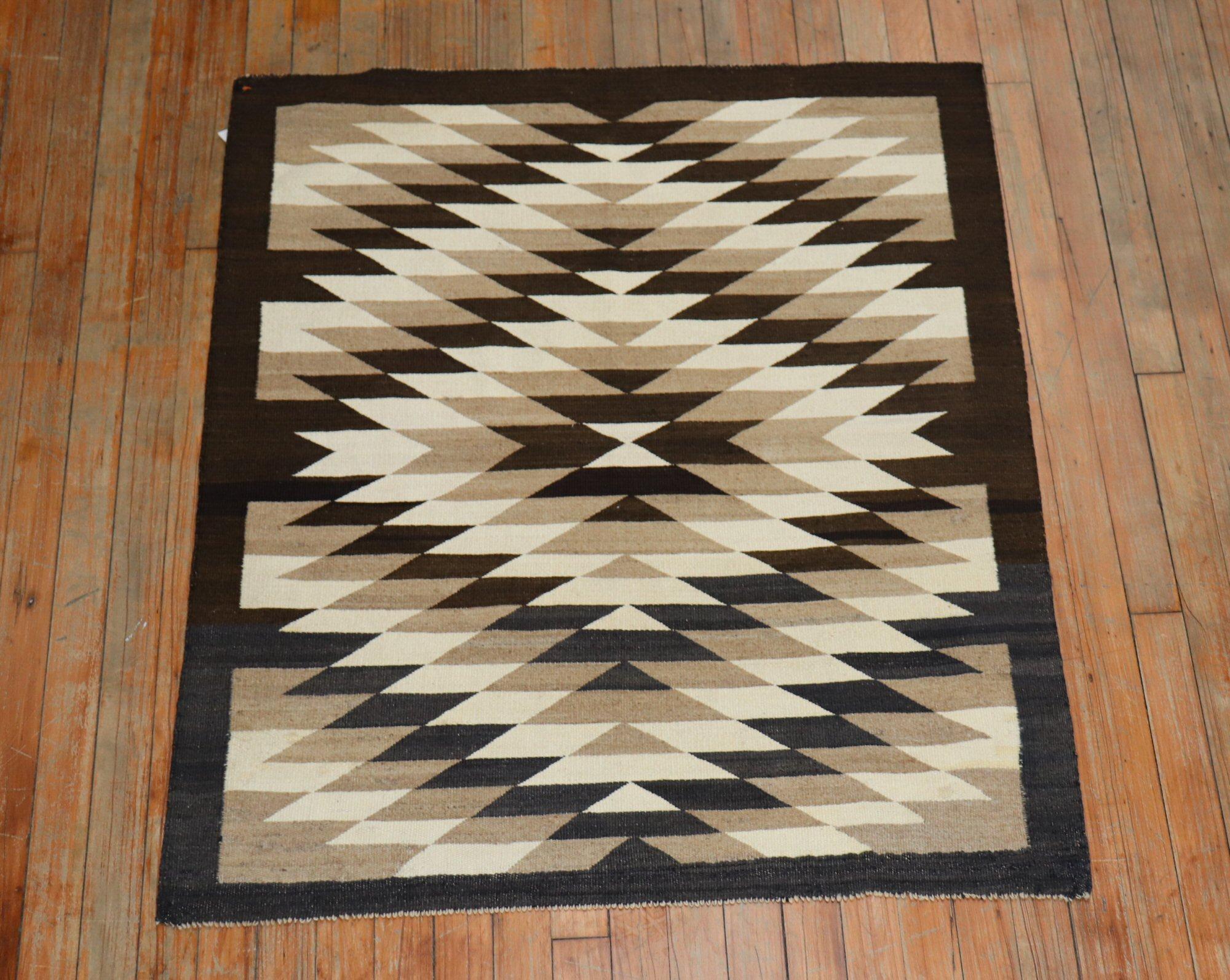 A highly decorative 20th century American Navajo rug with an all-over geometric tribal design in brown, charcoal, camel, and ivory

Measures: 3' x 3'8''.
 