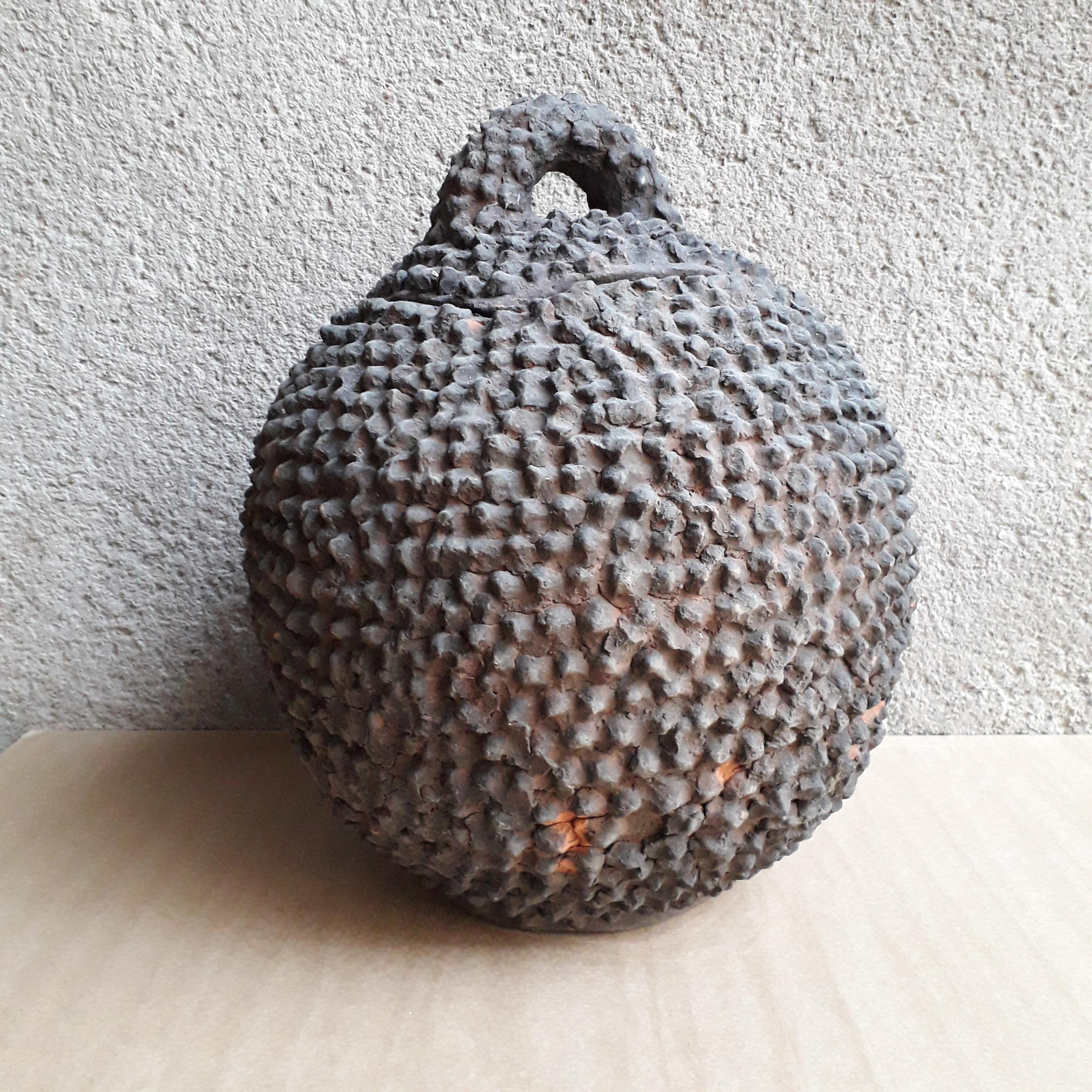 Jar jar made of earth from Burkina Faso, used for the production of Mil beer, known as Kogno. Usual traditional object made by hand, 2 or 3 pins are missing, small repair near the lid (invisible when the lid is closed).
Measures: Height 44 cm,