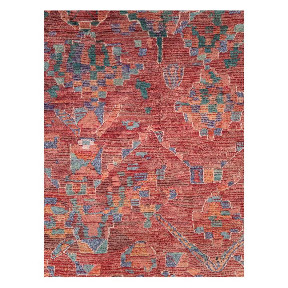 A vintage Moroccan rug in gallery format handmade during the late 20th century with tribal design elements over a deep red field.

Measures: 5' 9