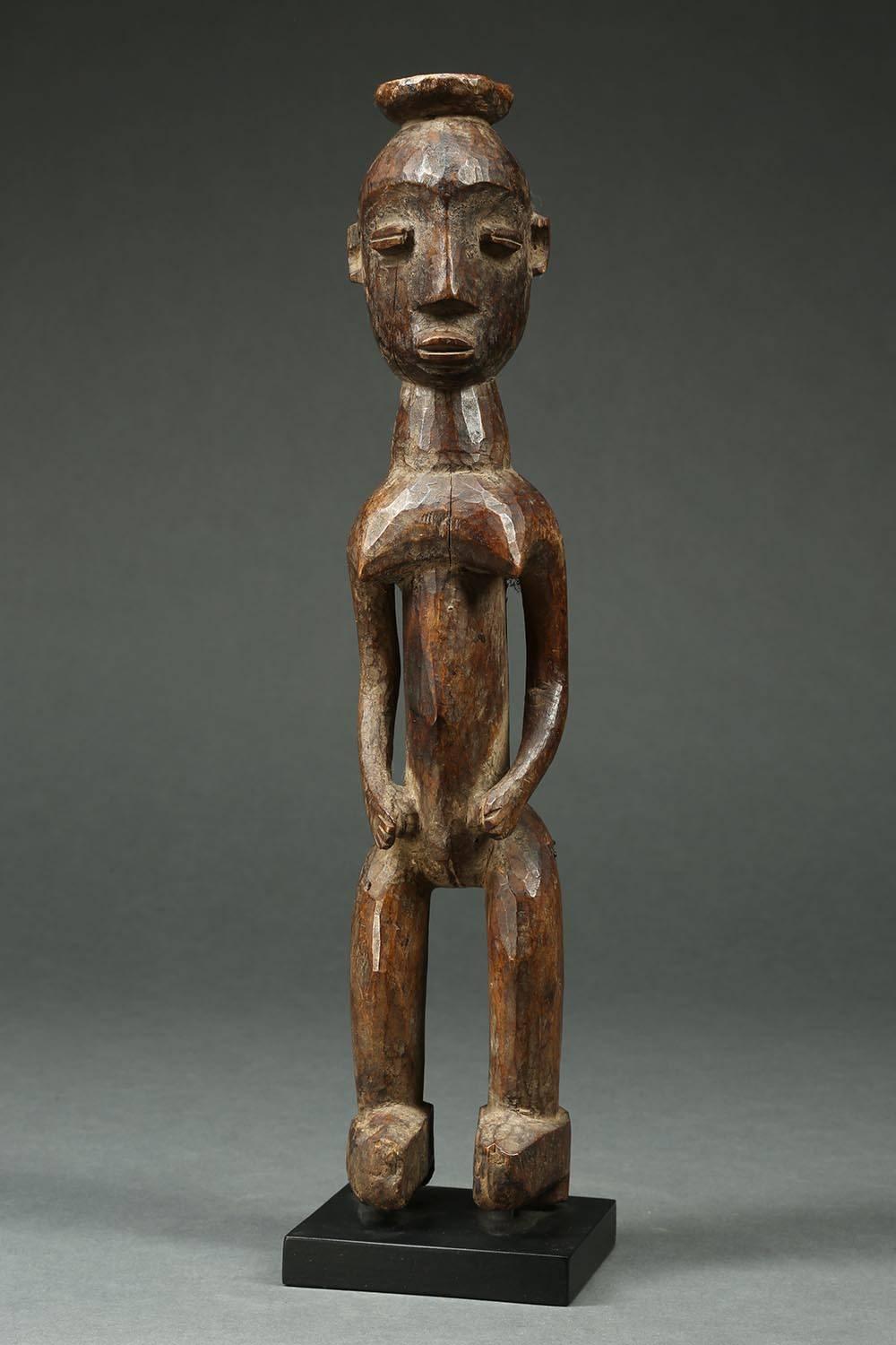 Tribal Lobi standing female figure, Ghana, Africa

Standing female figure with offering bowl on top of her head, nice sculpture, early colonial influence shown in high heel shoes.
Mid-20th century, 15