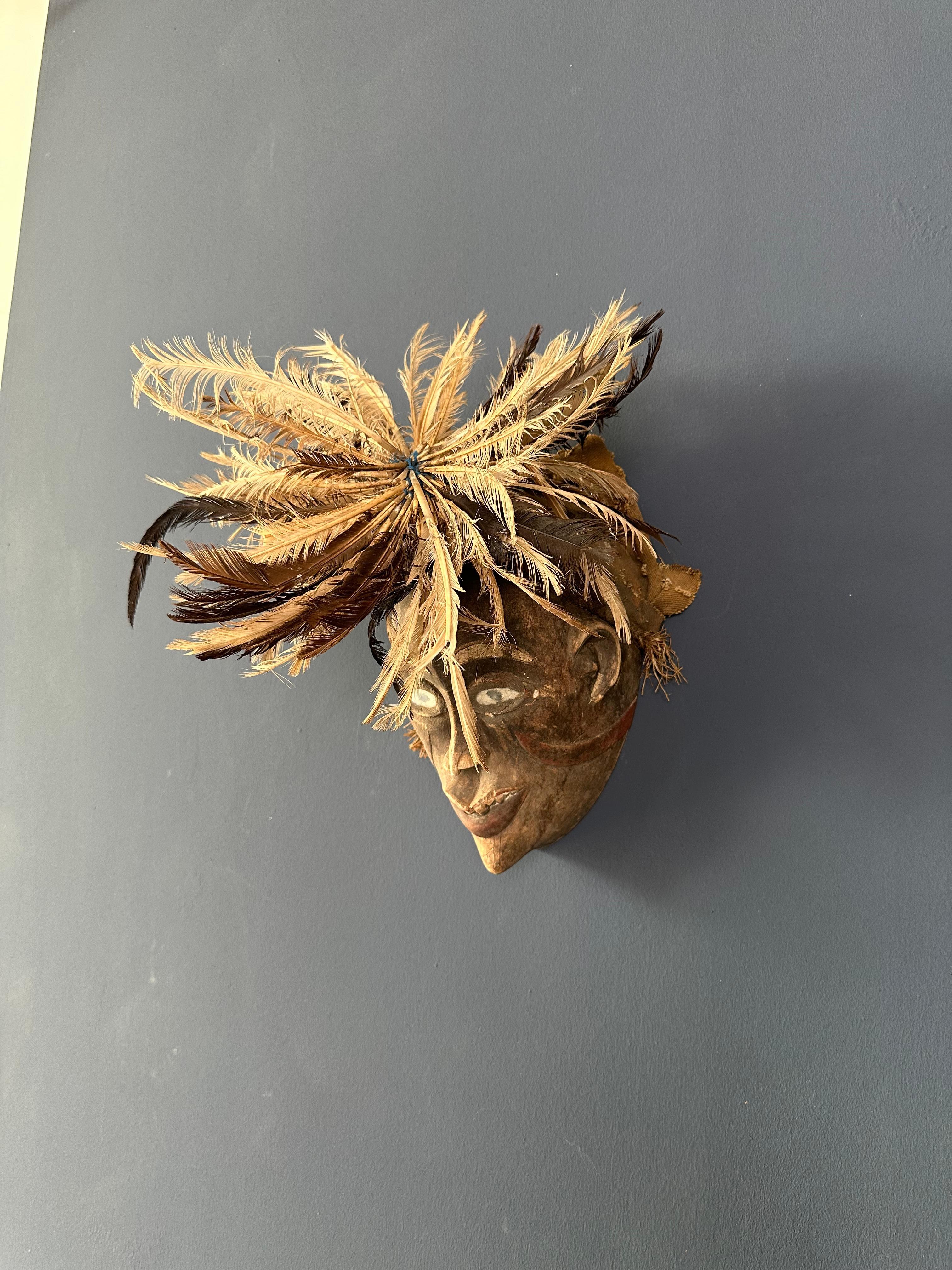 Bois Masque tribal avec décoration de tête de plumes en vente