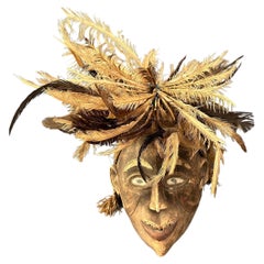 Maschera tribale con decorazione della testa con piume