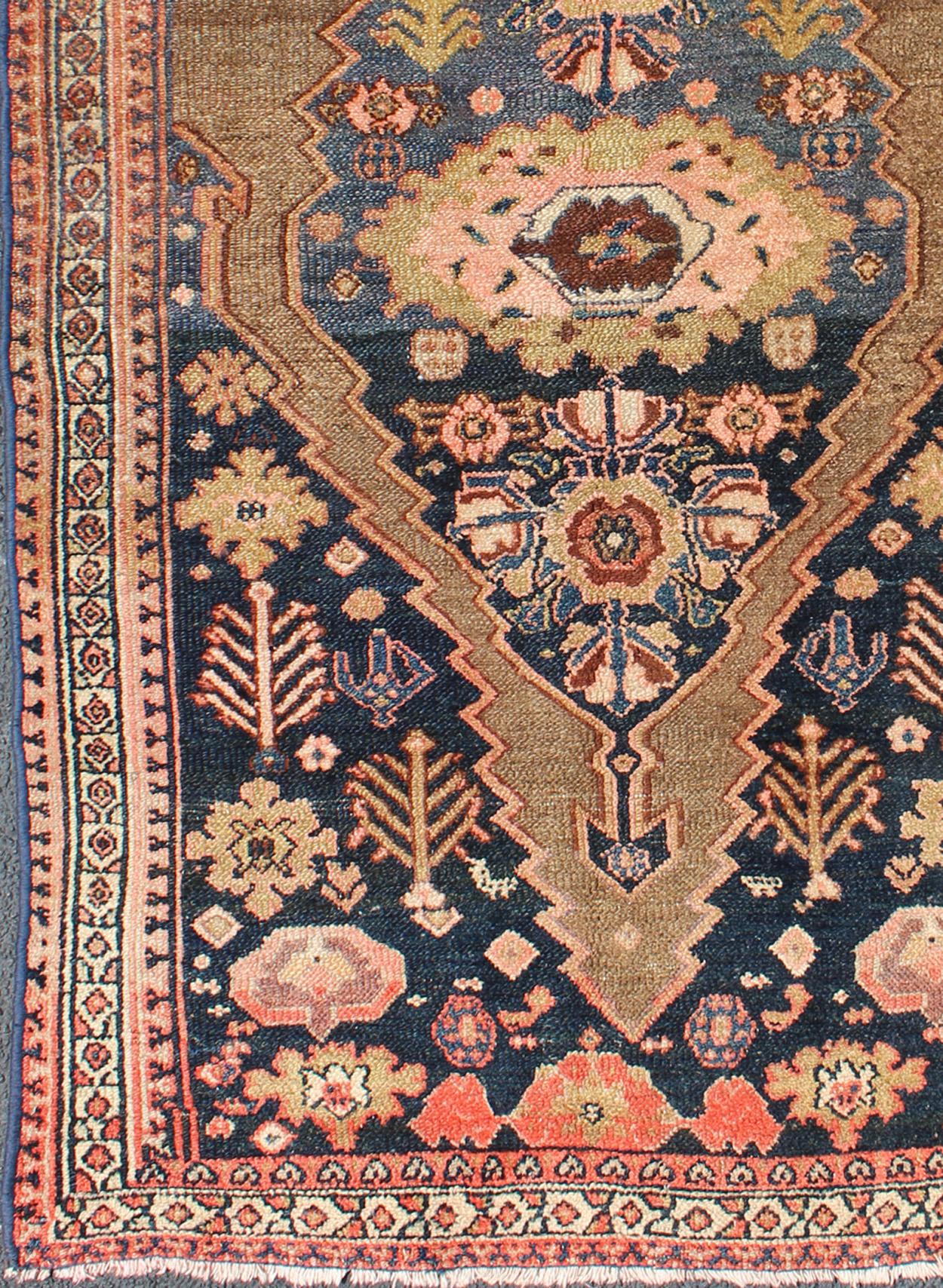 This antique Persian Serab antique rug with Medallion design in camel and shades of blue, rug zir-18, country of origin / type: Iran / Serab, circa 1900.

This handwoven, antique Persian Serab rug features a central field imbued with a stretched