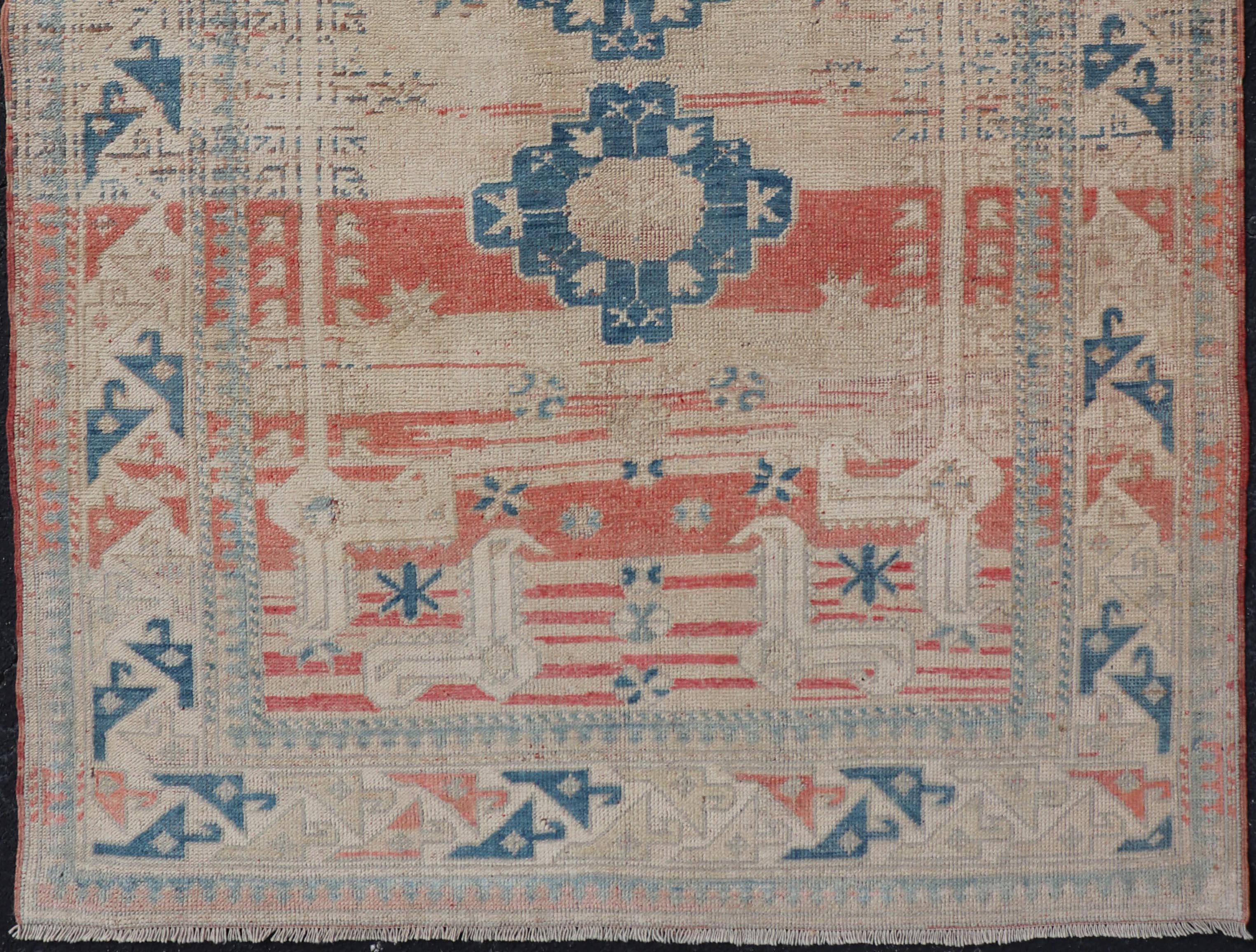 Measures: 4'5 x 6'7 

This vintage Oushak has repeating motifs in terracotta, cream, and blue encasing multiple motifs and the striped field. The eccentric field features two medallions in rich blue and accessorized lightly with cream colored