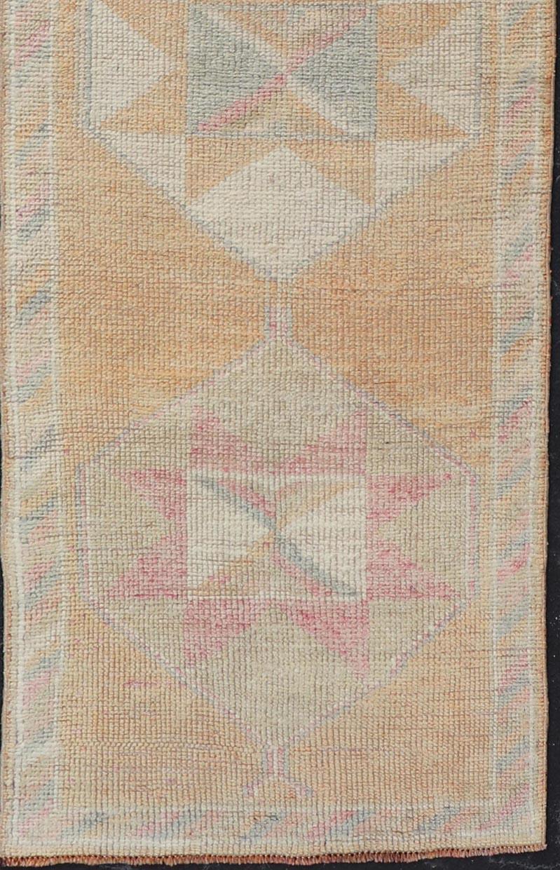 Measures: 2'9 x 12'0 

This very unique Oushak is uncommon in its design, from the bright and creamy orange background to the angular and sharp medallions centered in the field. Accent colors include muted shades of pink, blue, and