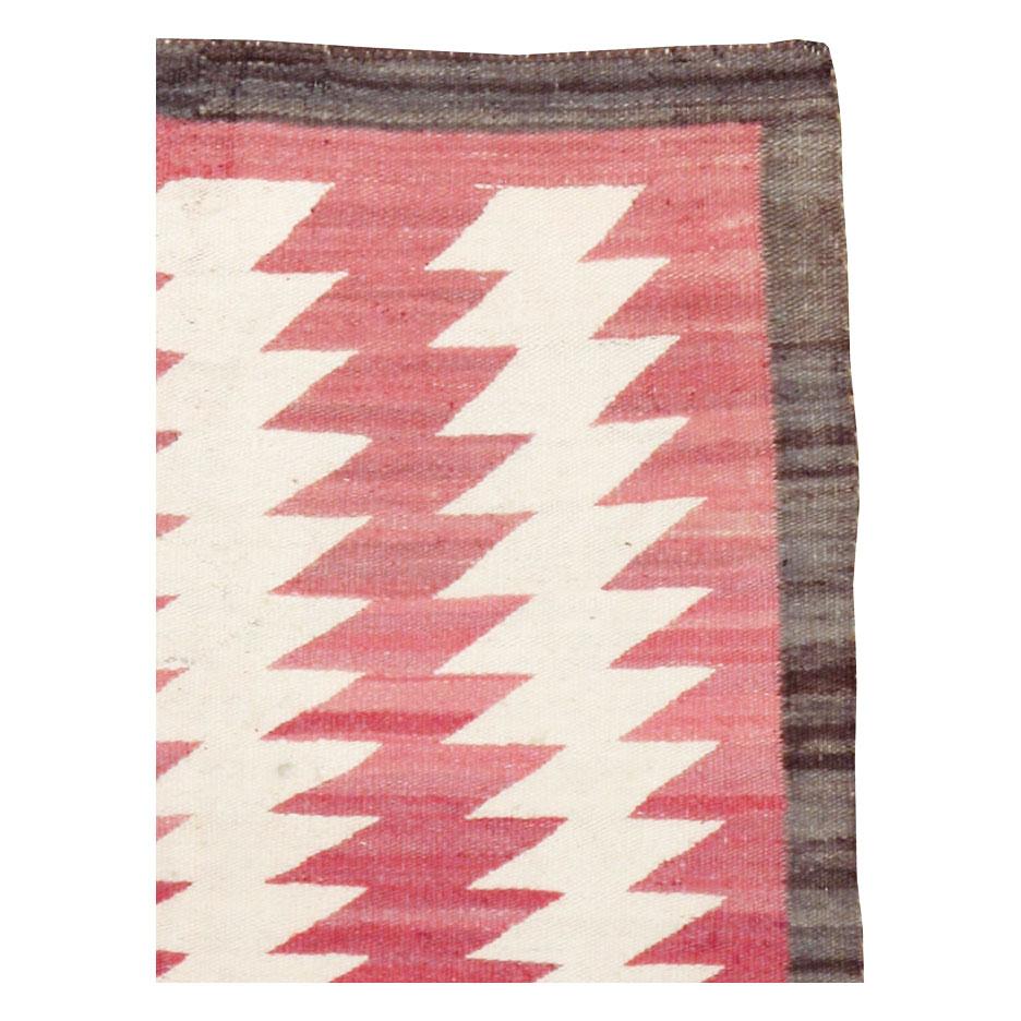A vintage American flatweave throw rug handmade by the Navajo tribe during the mid-20th century.

Measures: 2' 7