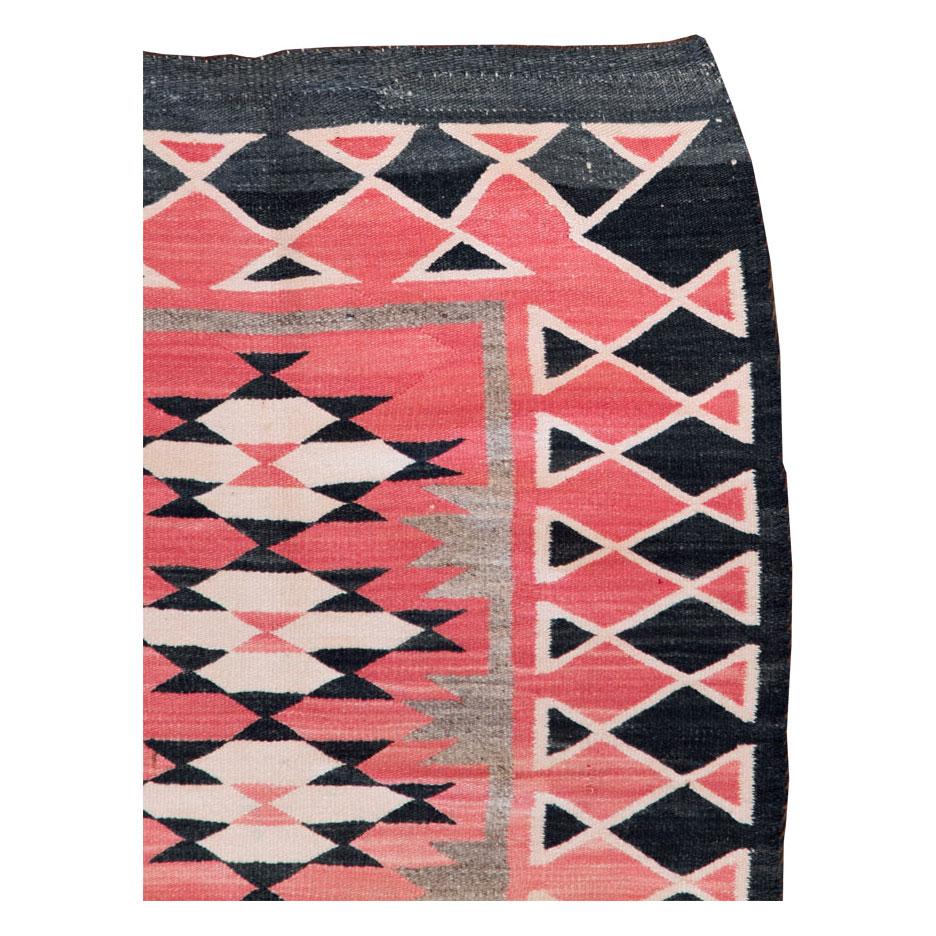 A vintage American flatweave throw rug handmade by the Navajo tribe during the mid-20th century.

Measures: 2' 7