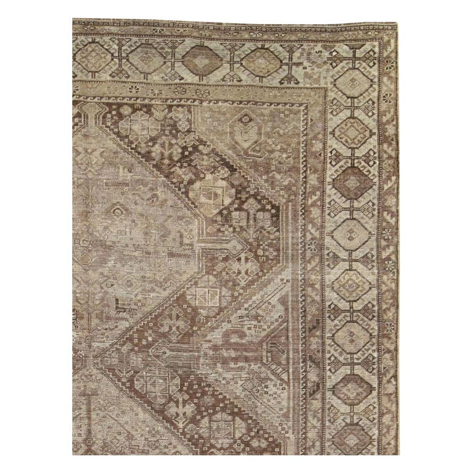 Ein alter persischer Shiraz-Teppich aus der Mitte des 20. Jahrhunderts mit einem geometrischen Stammesmuster in Creme- und Brauntönen.

Maße: 6'3