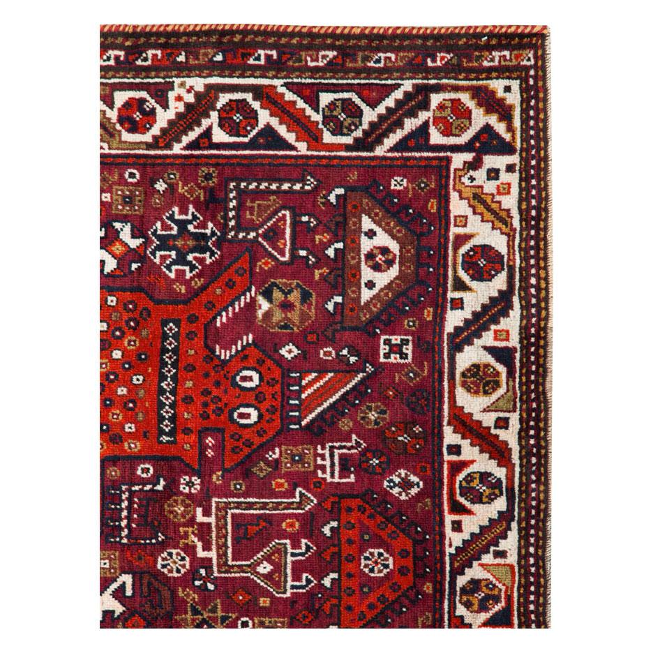 A vintage Persian Qashqai accent rug handmade during the mid-20th century with a whimsical pictorial depiction of a lion over a burgundy colored field encompassing several tribal design elements.

Measures: 4' 6