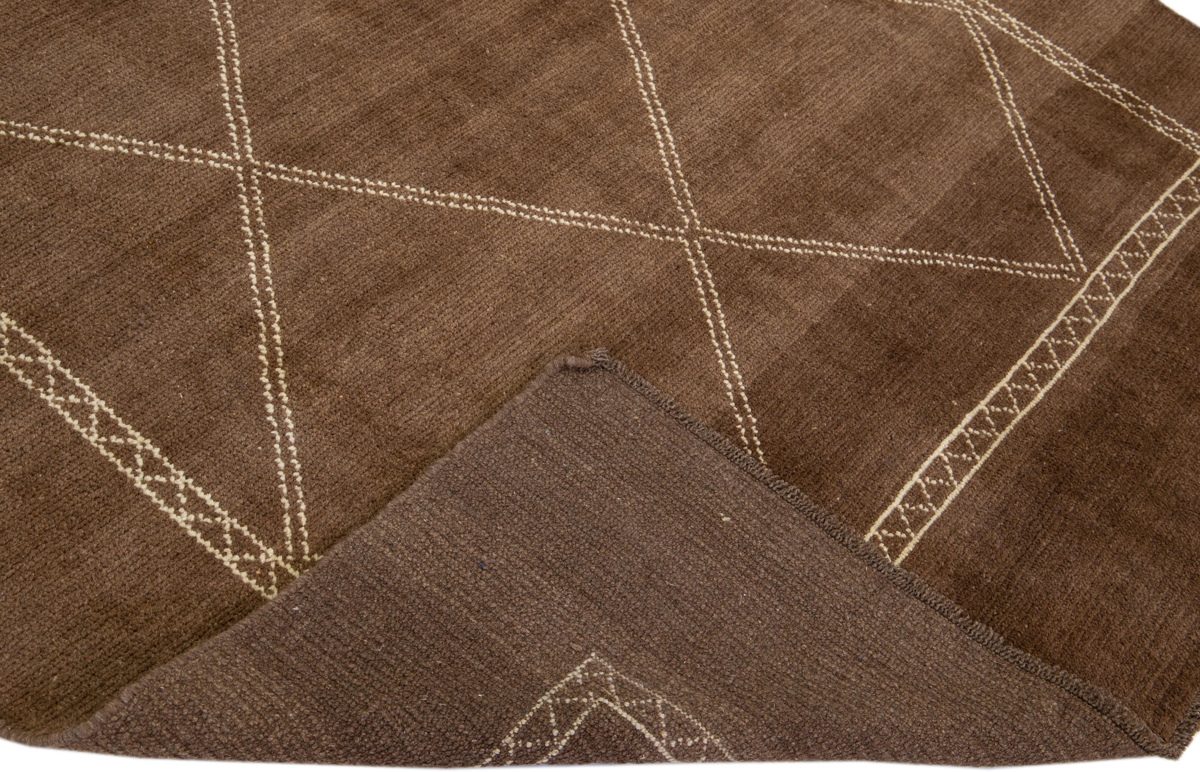 This Beautiful Moroccan-style handmade wool rug makes part of our Northwest collection and features a brown color field and beige accents in a gorgeous geometric tribal design.

This rug measures: 6'6