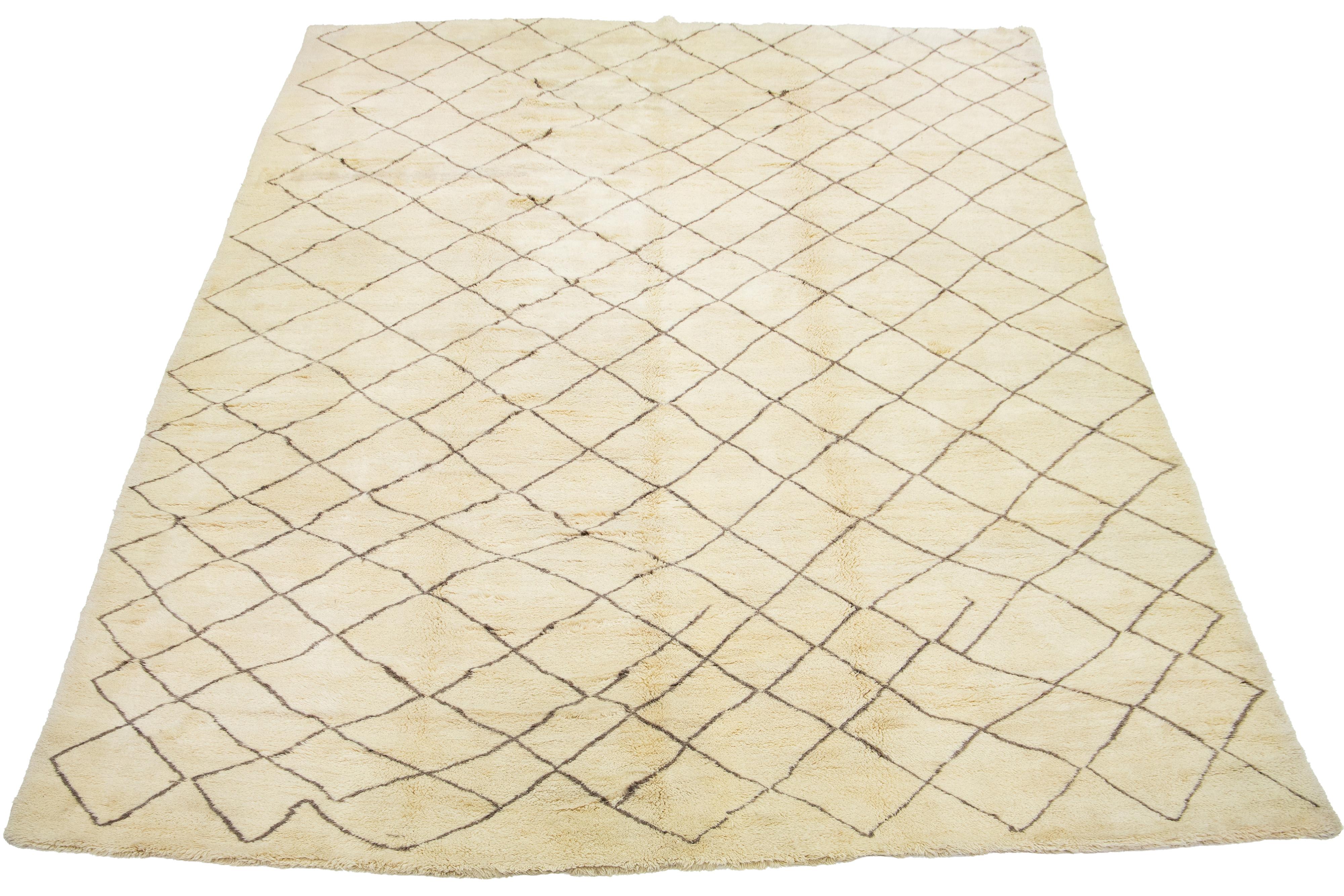 Ein atemberaubender, moderner Wollteppich im marokkanischen Stil, sorgfältig von Hand geknüpft mit einem beigen Grundton, der durch braune Akzente in einem fesselnden geometrischen Allover-Muster ergänzt wird.

Dieser Teppich misst 13'11'' x 20'10''.
