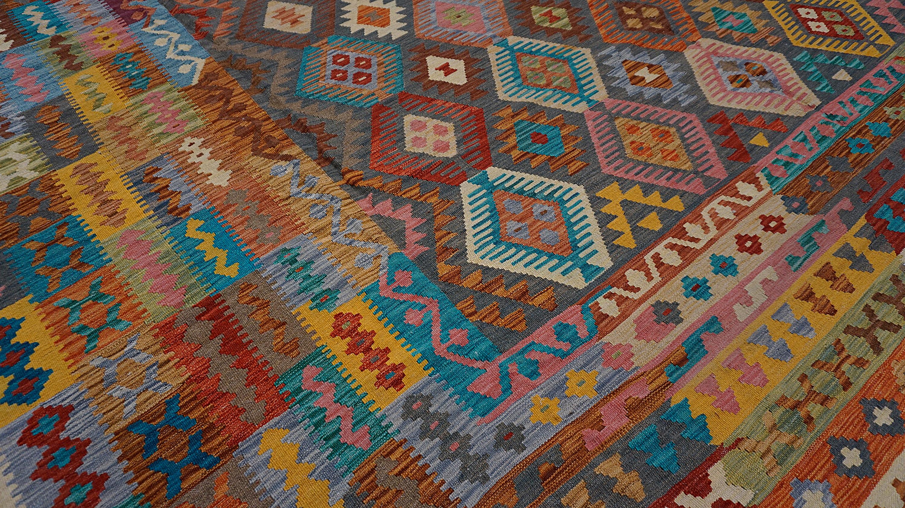This hand-woven wool Kilim rug is a radiant example of traditional tribal weaving reimagined with a vibrant modern palette. Featuring a tightly arranged field of multicolored diamond motifs enclosed by multiple intricate borders, the design pays