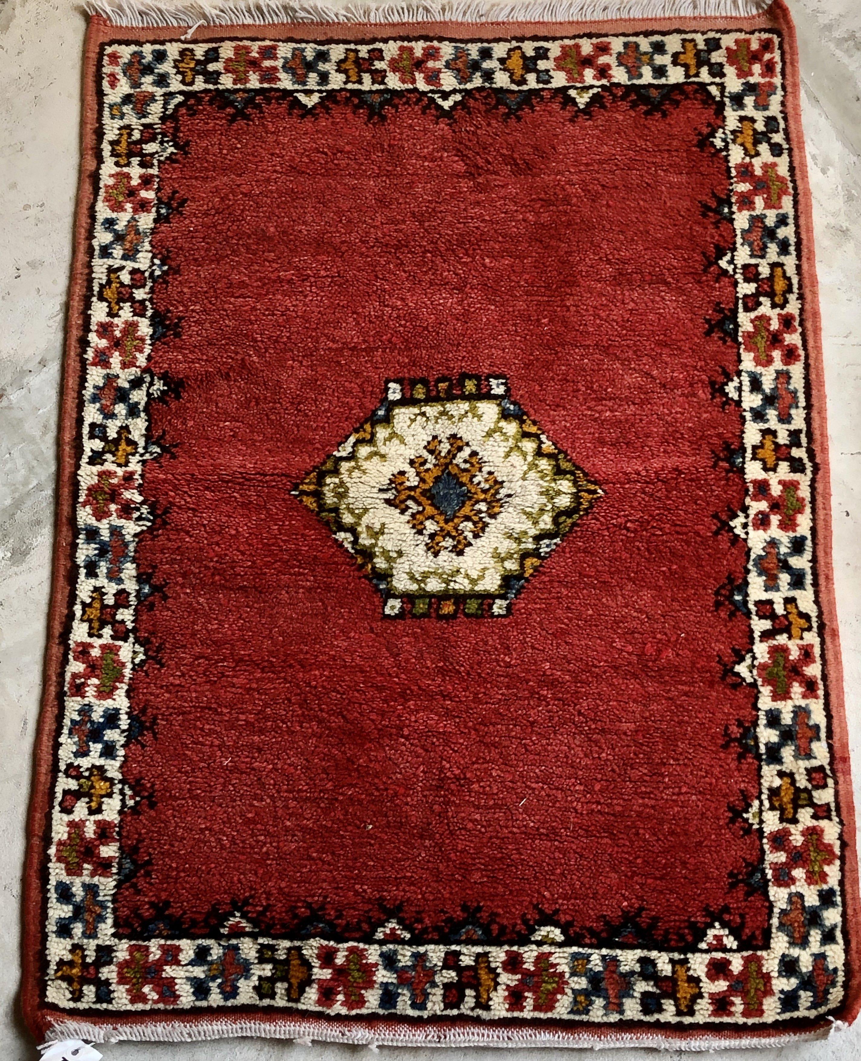 Indulge in the luxury of history with this vintage tribal Moroccan rug, handwoven with intricate geometrical designs and sheep wool. A diamond-shaped motif at the center adds a sophisticated touch to any room or space. Elevate your home with this