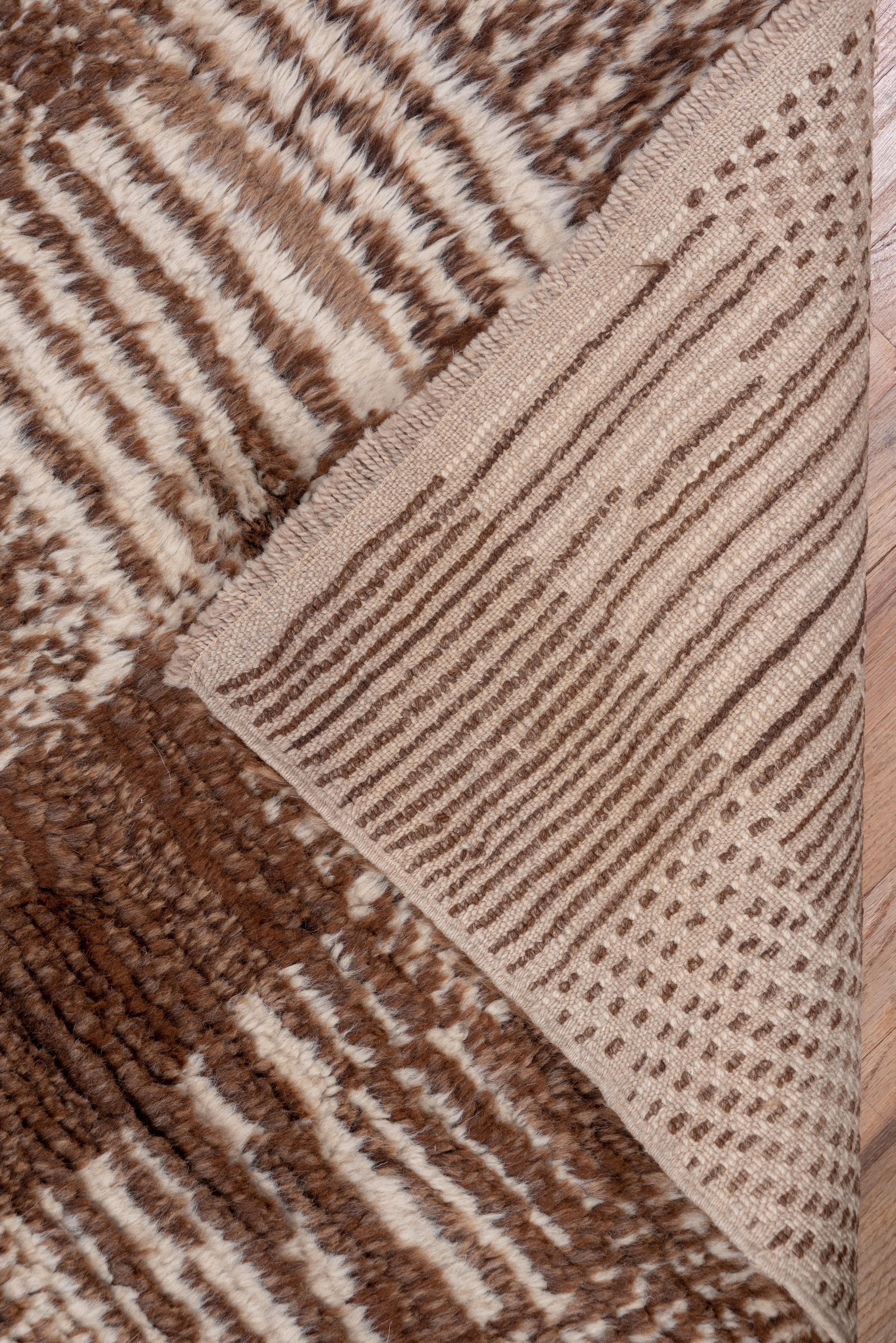 A five column patchwork square pattern in solid brown, as well as vertically and horizontally lined, speckled and diagonally lined has a vaguely rustic hooked rug aura.
