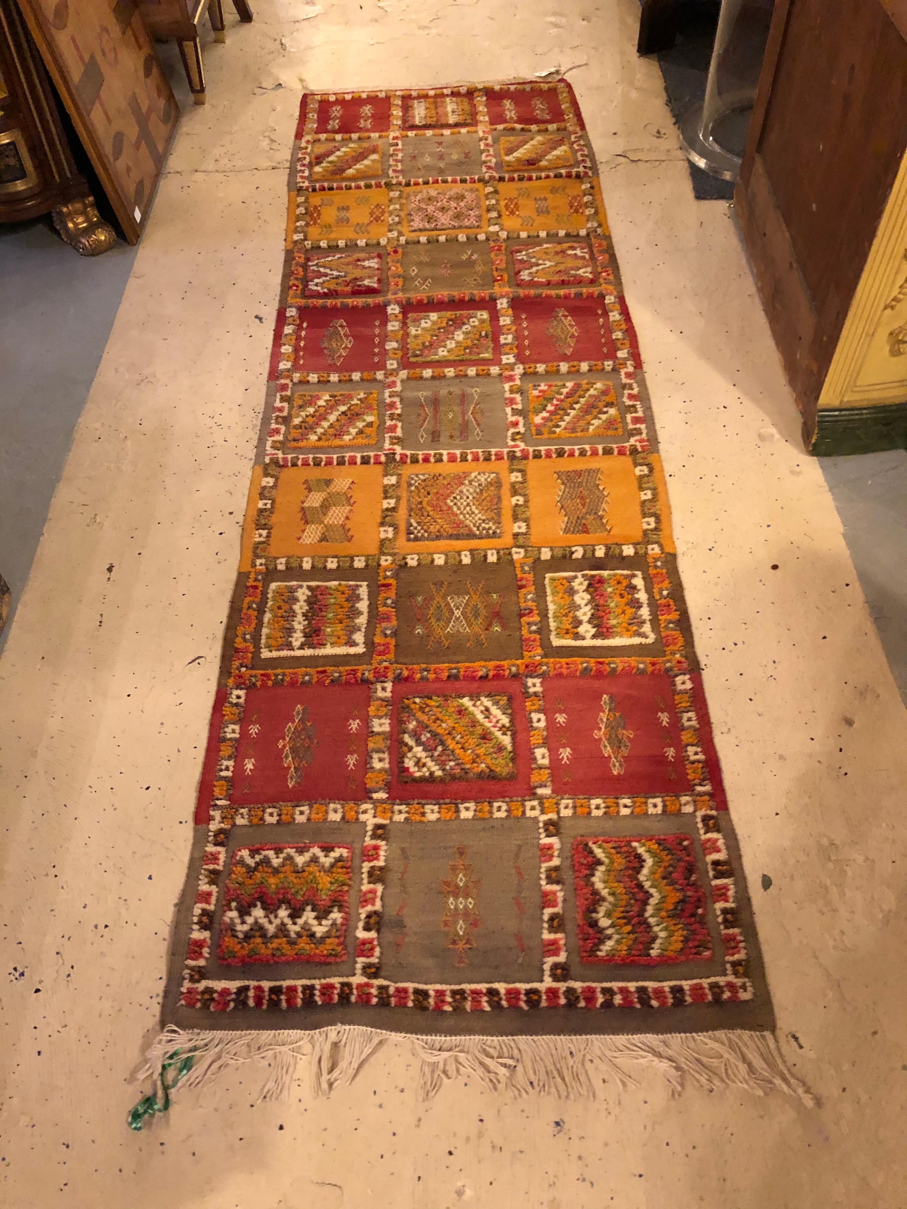 This elegant vintage tribal Moroccan runner rug or carpet is an ennobling addition to hallways, foyers, entryways, dressing rooms, staircases and wherever else a slender rug is desired. Hand-woven rug from the Taznacht region of Morocco, the runner