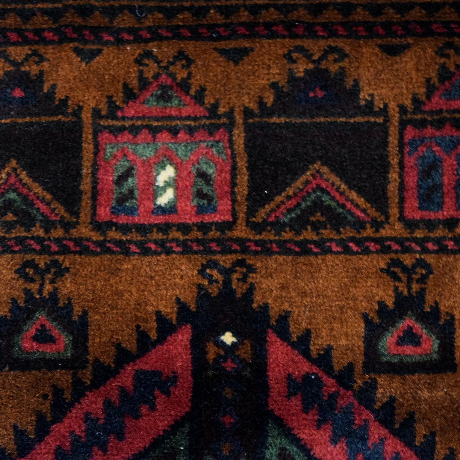 With harmonious shades of gold, black, green, red, and blue wool, this Persian Balouchi carpet belongs to Orley Shabahang’s World Market Collection. Measuring 2’11” x 4’4”, this carpet is entirely hand knotted using a traditional Persian weaving