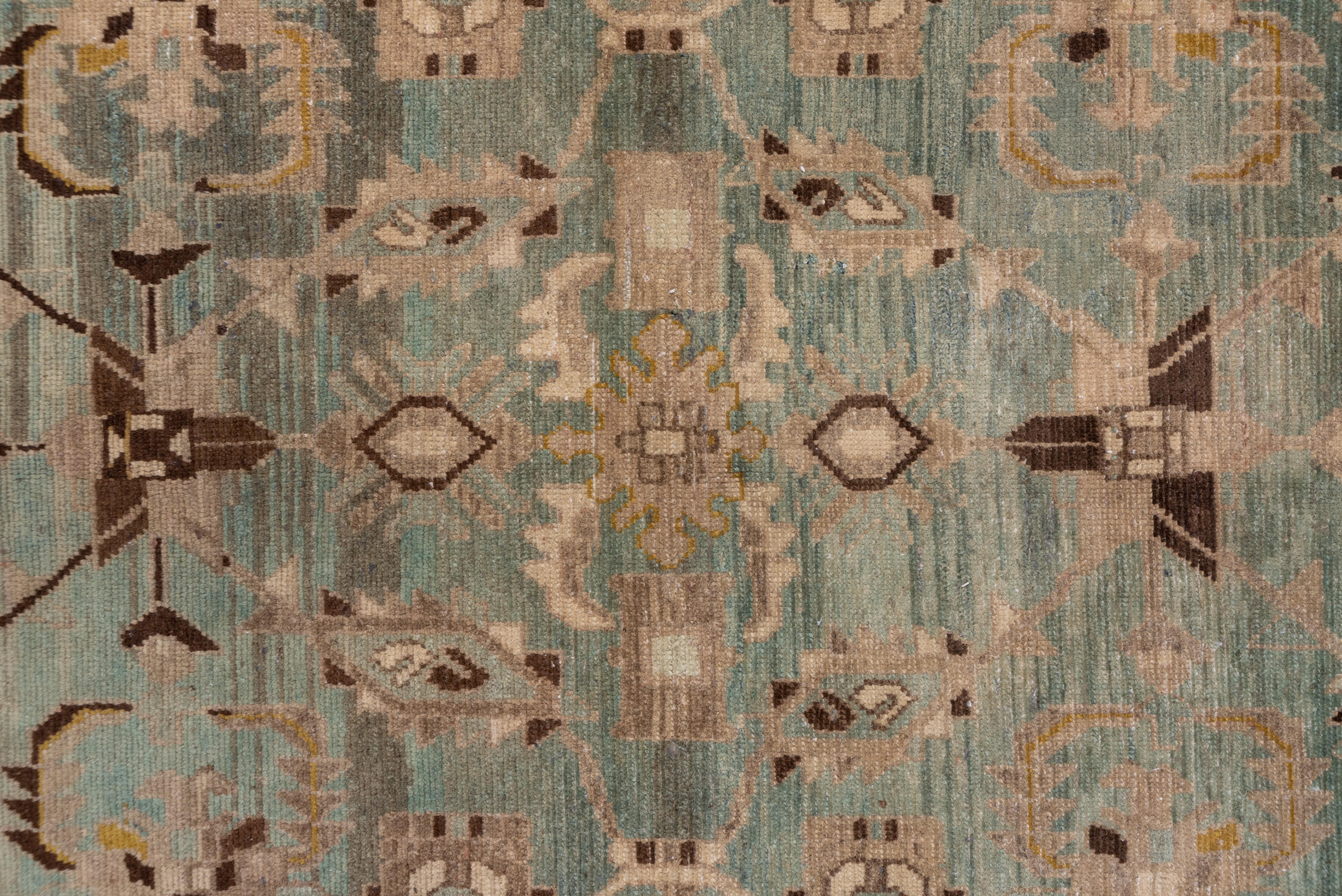 Dark brown accents are randomly distributed on this solidly woven west Persian scatter with an abrashed light grey field presenting octagons, squares, rhomboids and jagged leaves. Accents in goldenrod and rust appear, and the straw main border shows