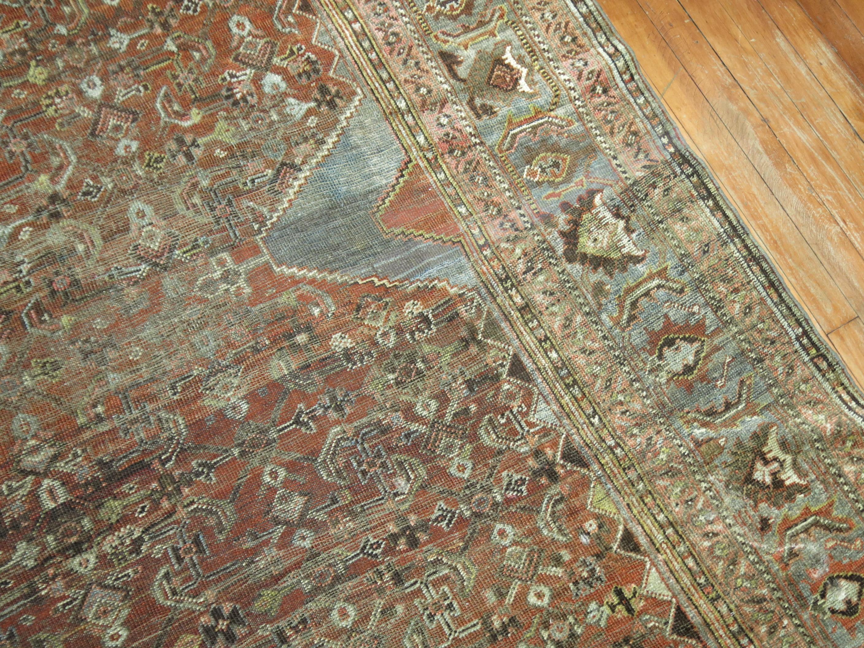 Early 20th century room size Persian rug with a tribal medallion motif on a brown rust ground.

 