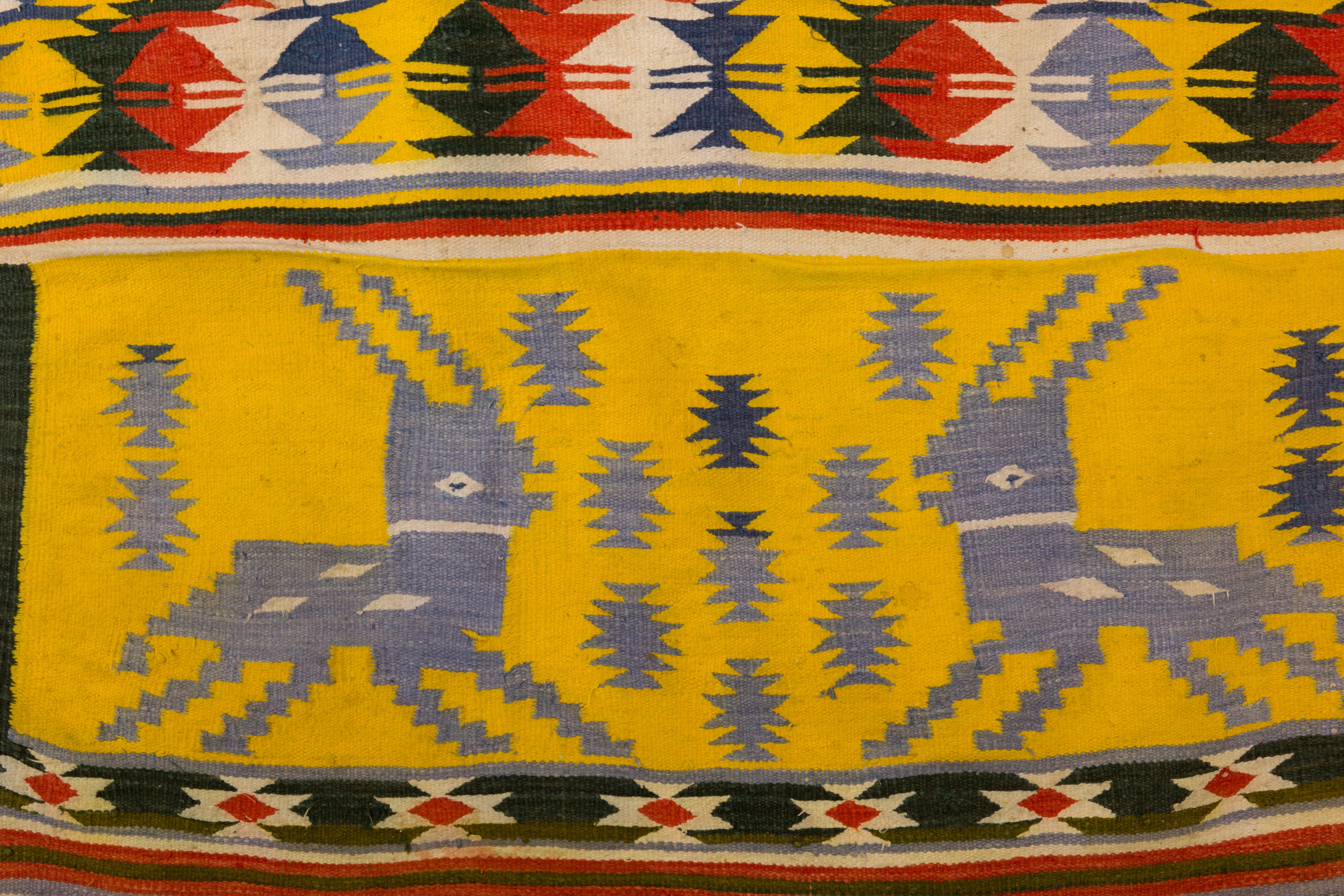 Midcentury handwoven multi-color cotton Dhurrie tribal rug with deer designs on each end. Hand knotted with fringe, Rajasthan, India, circa 1940s-1950s.