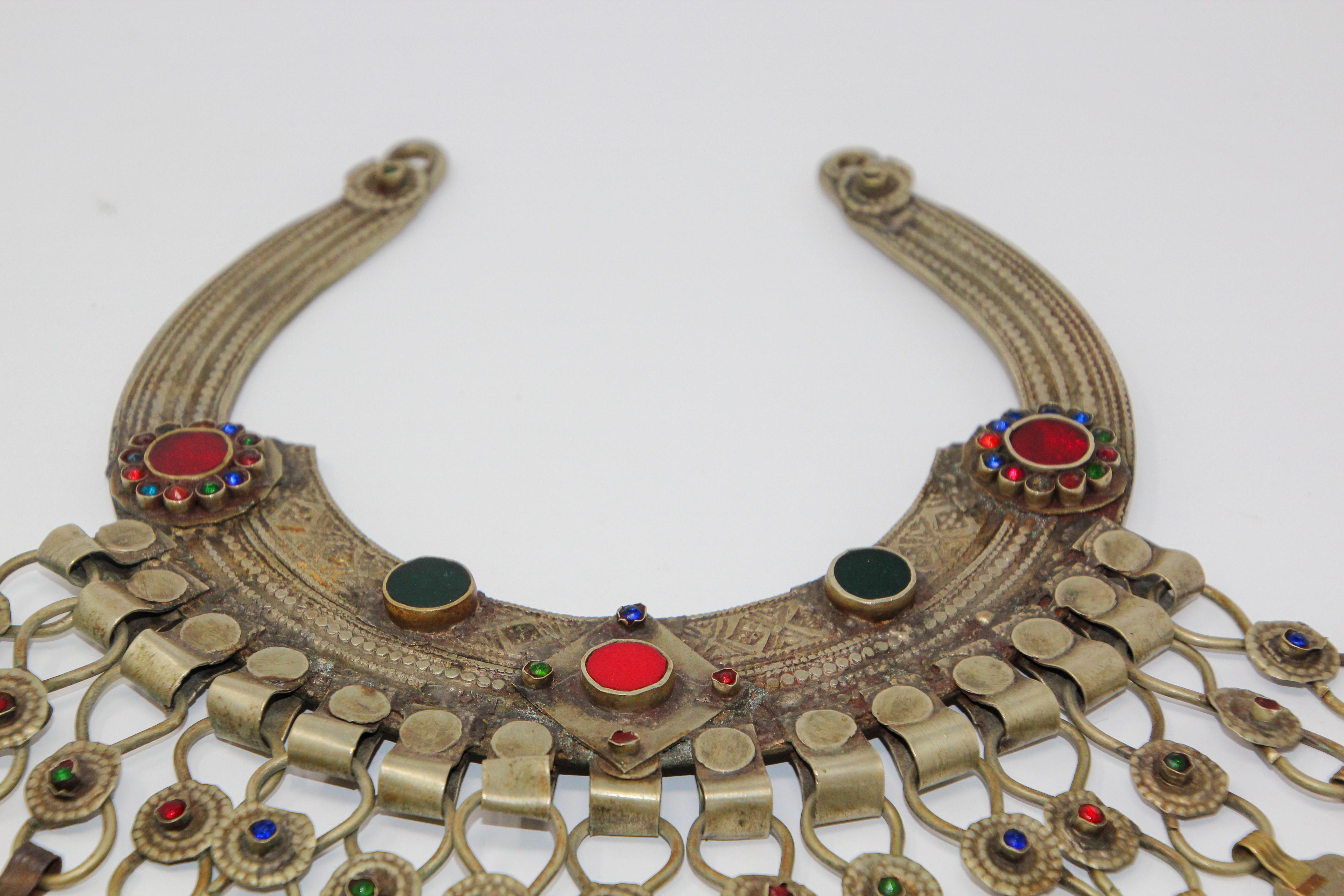 A Moroccan Tribal jewelry vintage chocker inlaid with colorful glass beads in red and green and dangling coins. 
German silver, but not of the standard of sterling and richly embellished with applied silver designs and filigree.
Chocker size: 10