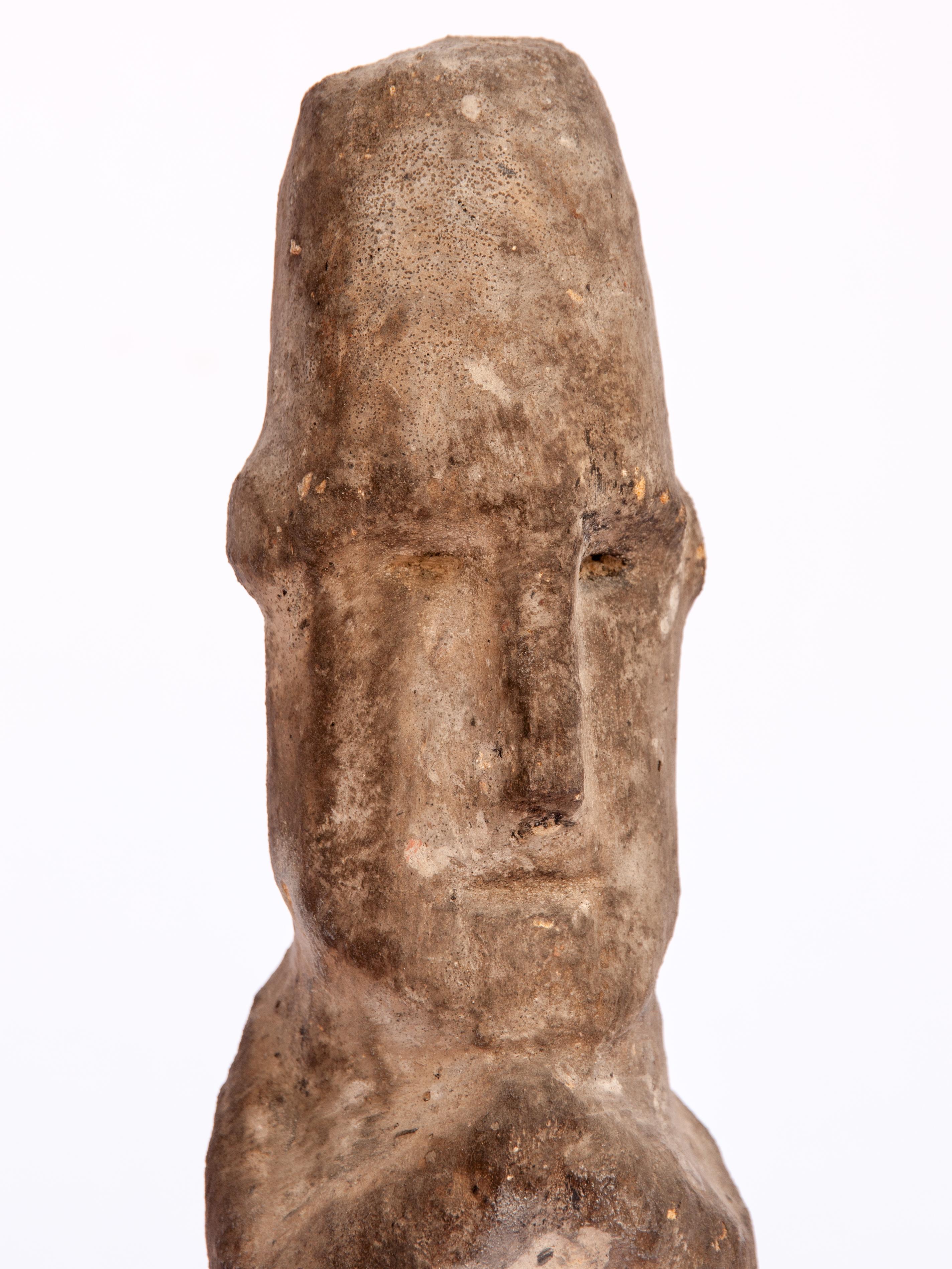 Tribal stone figure from West Nepal, early to mid-20th century. 17.25 inches tall. Mounted on a metal base.
This stone figure comes from West Nepal, most likely from Bajura District, or bordering areas of the Karnali Basin. It is posed sitting with
