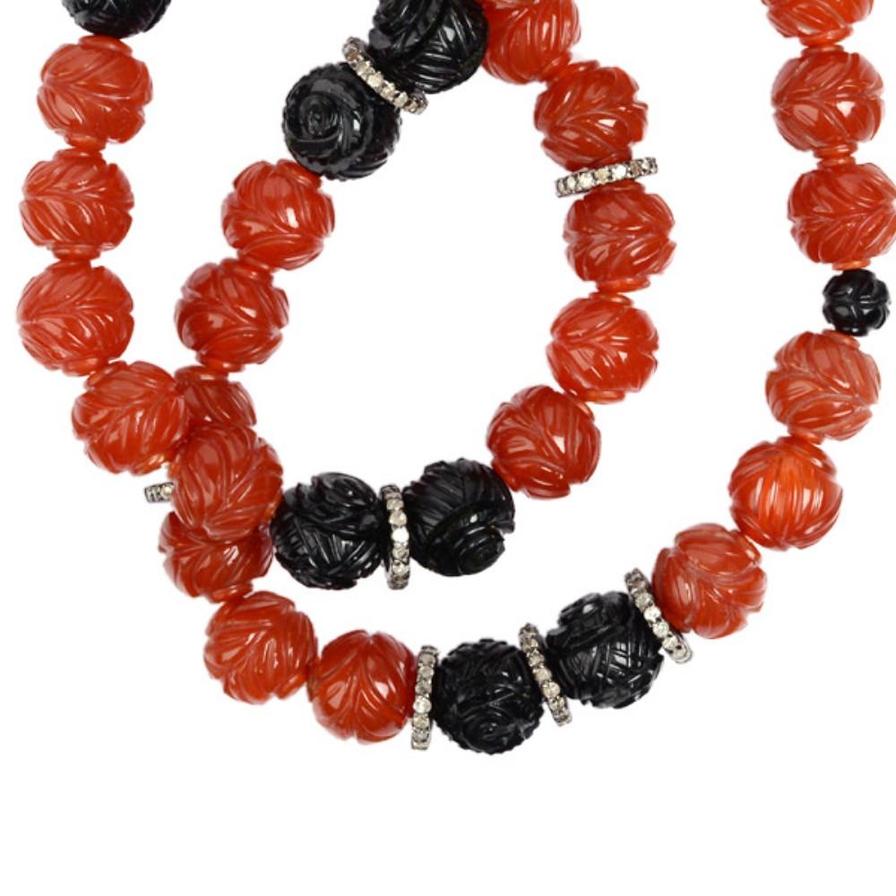 Enhance your jewelry collection with this stunning Tribal Style Carved Agate & Onyx Beaded Necklace. Made with silver, this unique piece features intricate carvings and sparkling diamonds, making it a perfect addition to any outfit. Get ready to