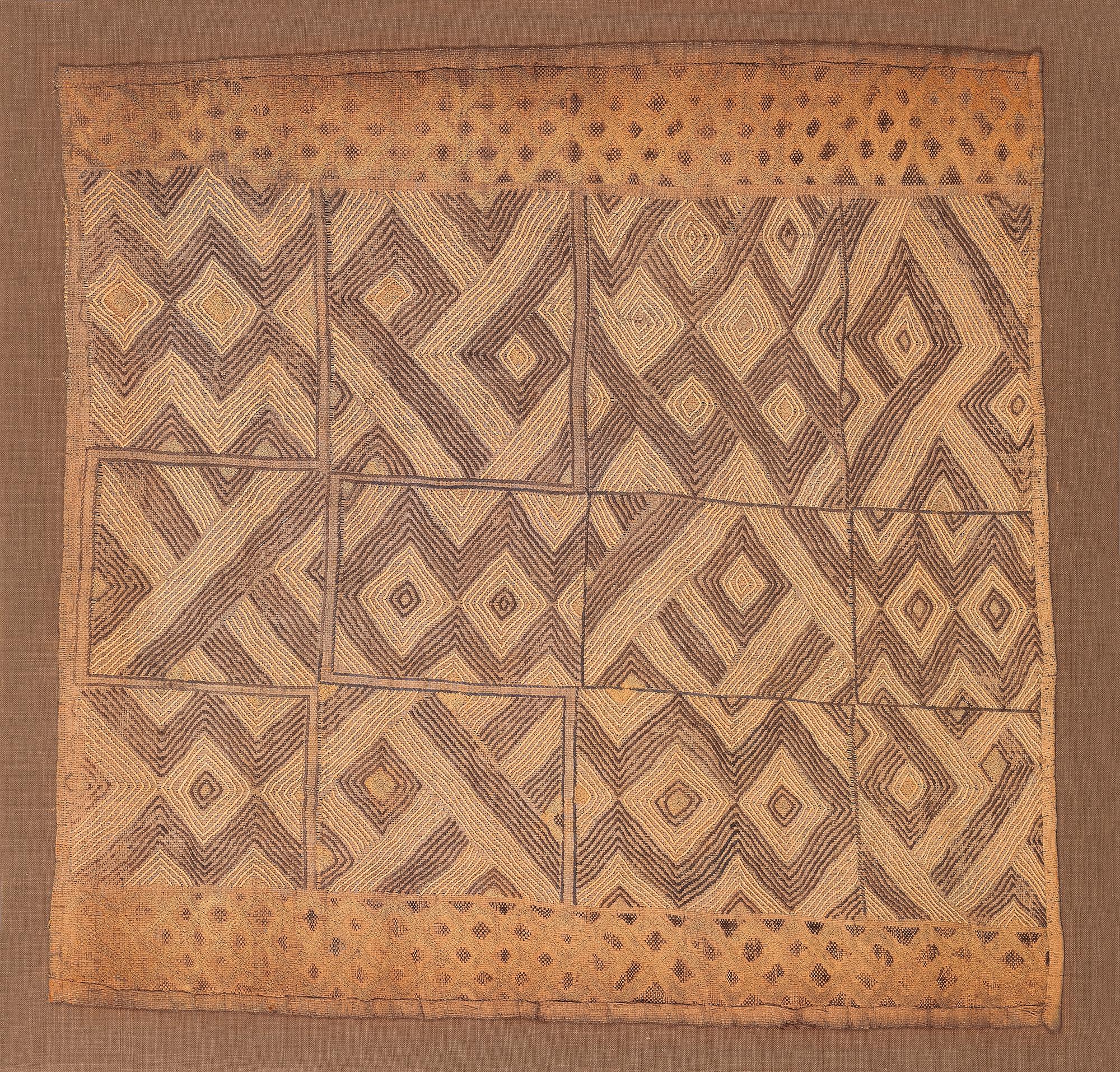 A late 19th or early 20th century Kuba Prestige cloth, mostly embroidered with cut pile borders.