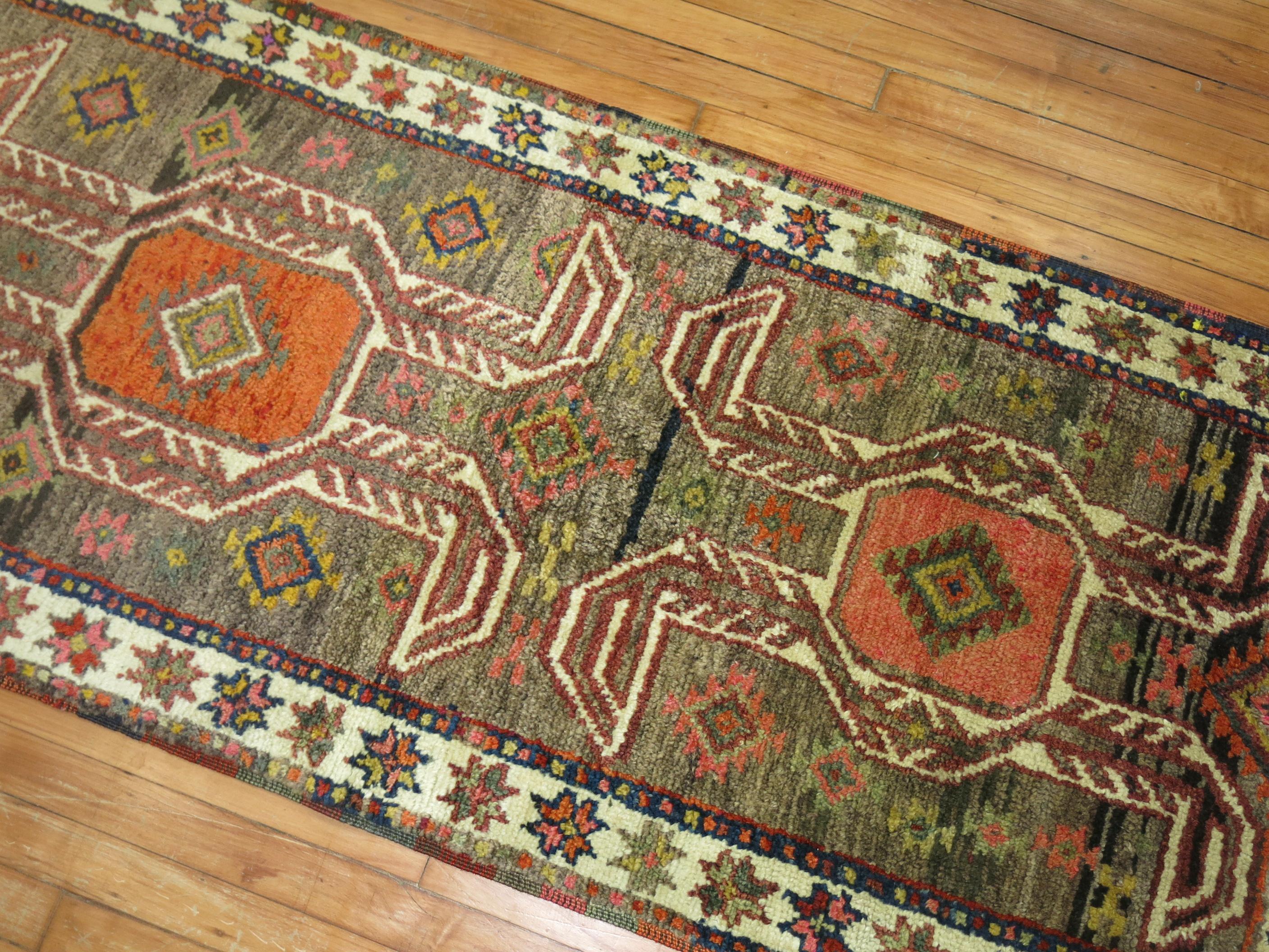 Mid 20th century tribal Turkish Anatolian runner with a tribal design in brown, orange, pink and ivory dominant accents

Measures: 2'8