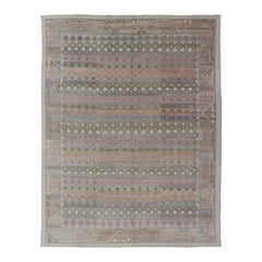 Alfombra turca tribal Oushak con motivos geométricos en tonos pastel suaves y verde oliva