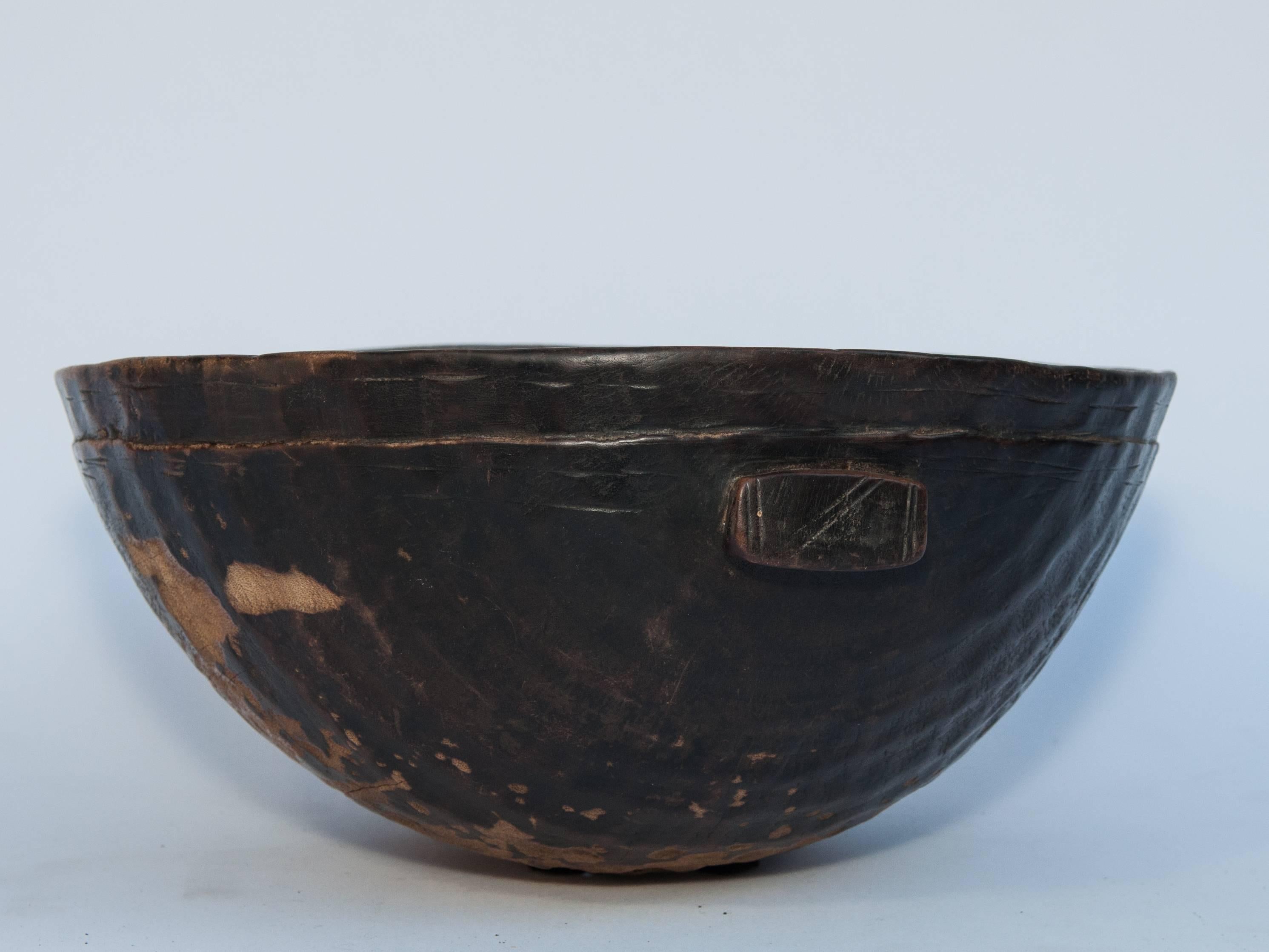 Tribal wooden bowl. Handhewn, from Mali, mid-20th century.
Offered by Bruce Hughes.
This rustic wooden bowl was fashioned by hand using very basic tools. It was used as a food or grain bowl. Eroded areas on the interior and exterior of the bowl