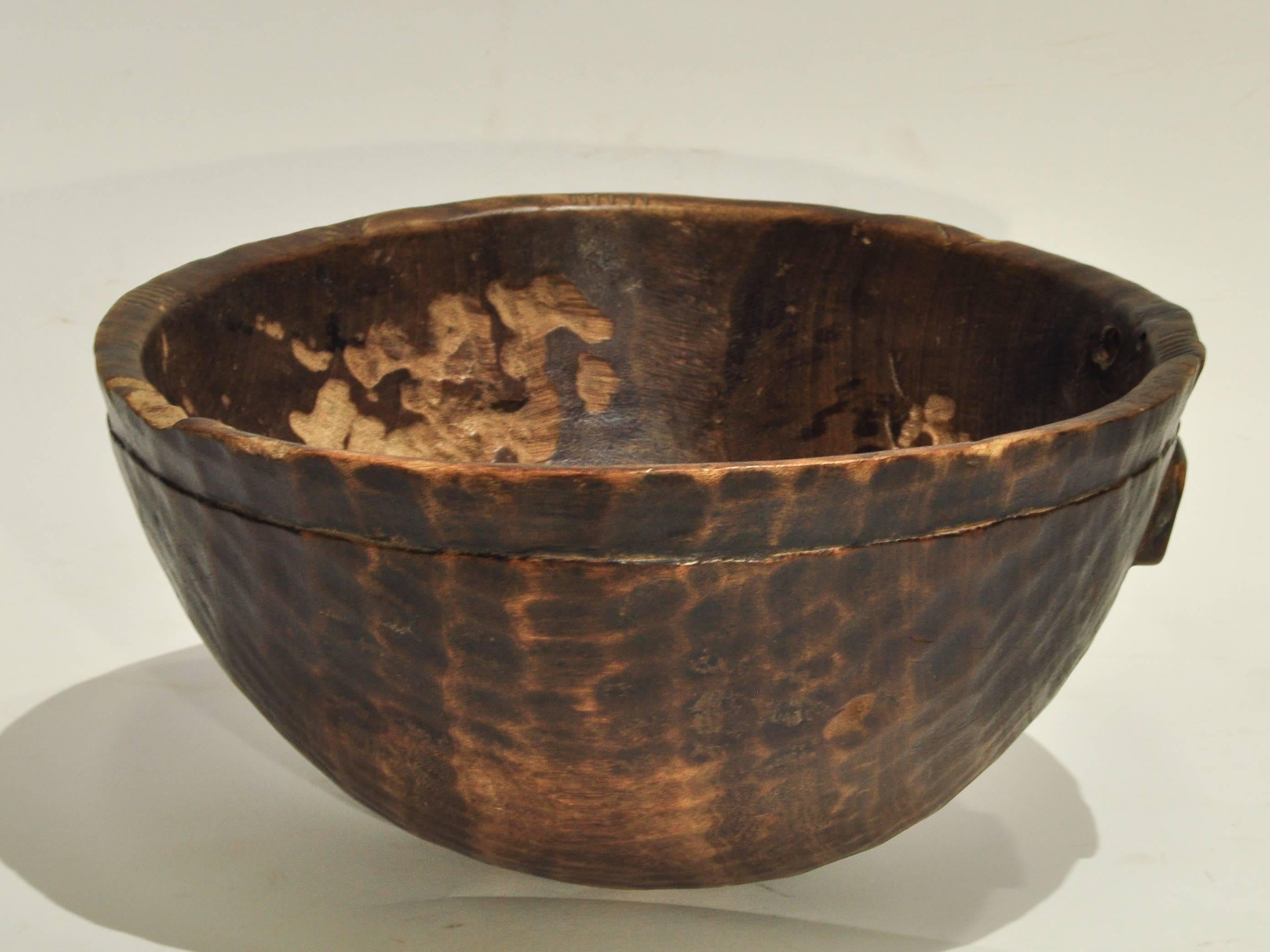 Tribal wooden bowl. Handhewn, from Mali, mid-20th century.
This rustic wooden bowl was fashioned by hand using very basic tools. The hand adzed texture of the outside surface of the bowl is particularly striking. The Inside of the bowl also has a