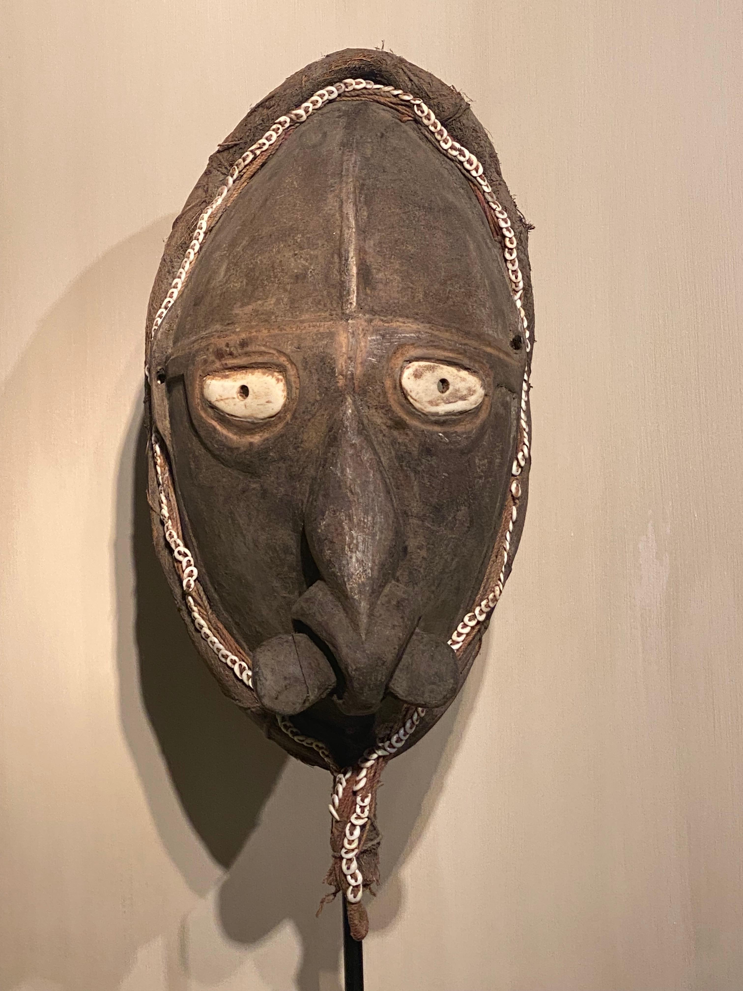 A tribal Wooden mask from Papua New Guinea, Sepik region,
good patina and wear of the mask, 
the mask is decorated with small shells and shell parts,
powerful object