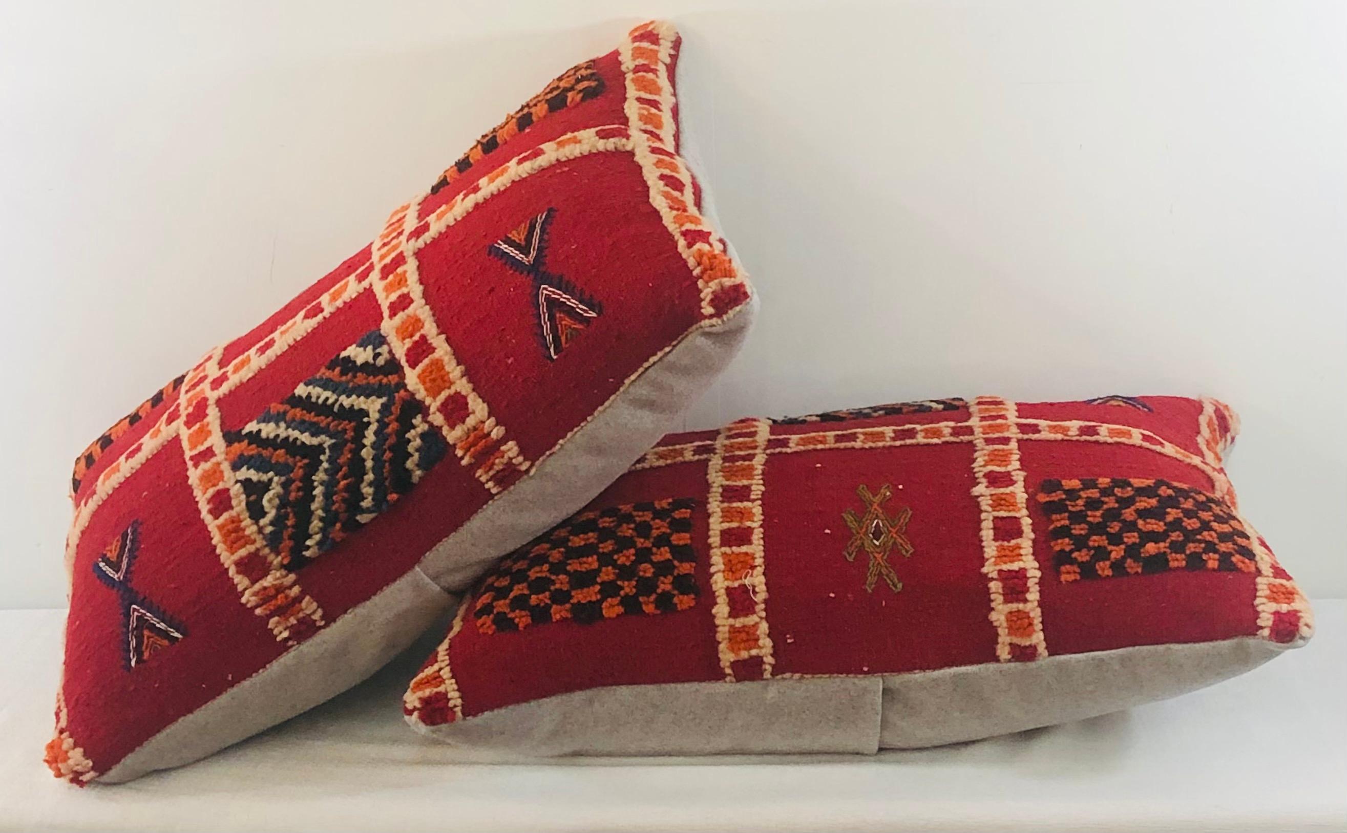 Featuring vivid and earthy burgundy, blue, off-white and green colors, this stunning one of a kind pair of Kilim pillows are custom made from a vintage Moroccan wool rug handwoven in the Atlas Mountains in Morocco by Berber women artisans. Handwoven