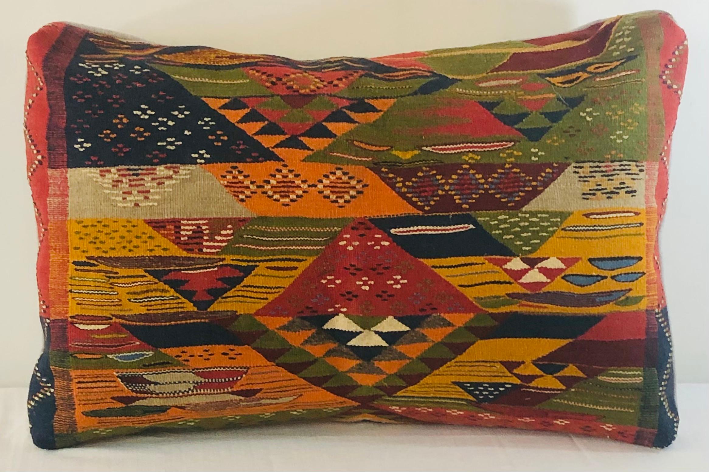 Featuring vivid dark blue, off white, earthy burgundy and green colors, this stunning one-of-a-kind pair of Kilim pillows are custom made from a vintage Moroccan wool rug handwoven in the Atlas Mountains in Morocco by Berber women artisans.

This