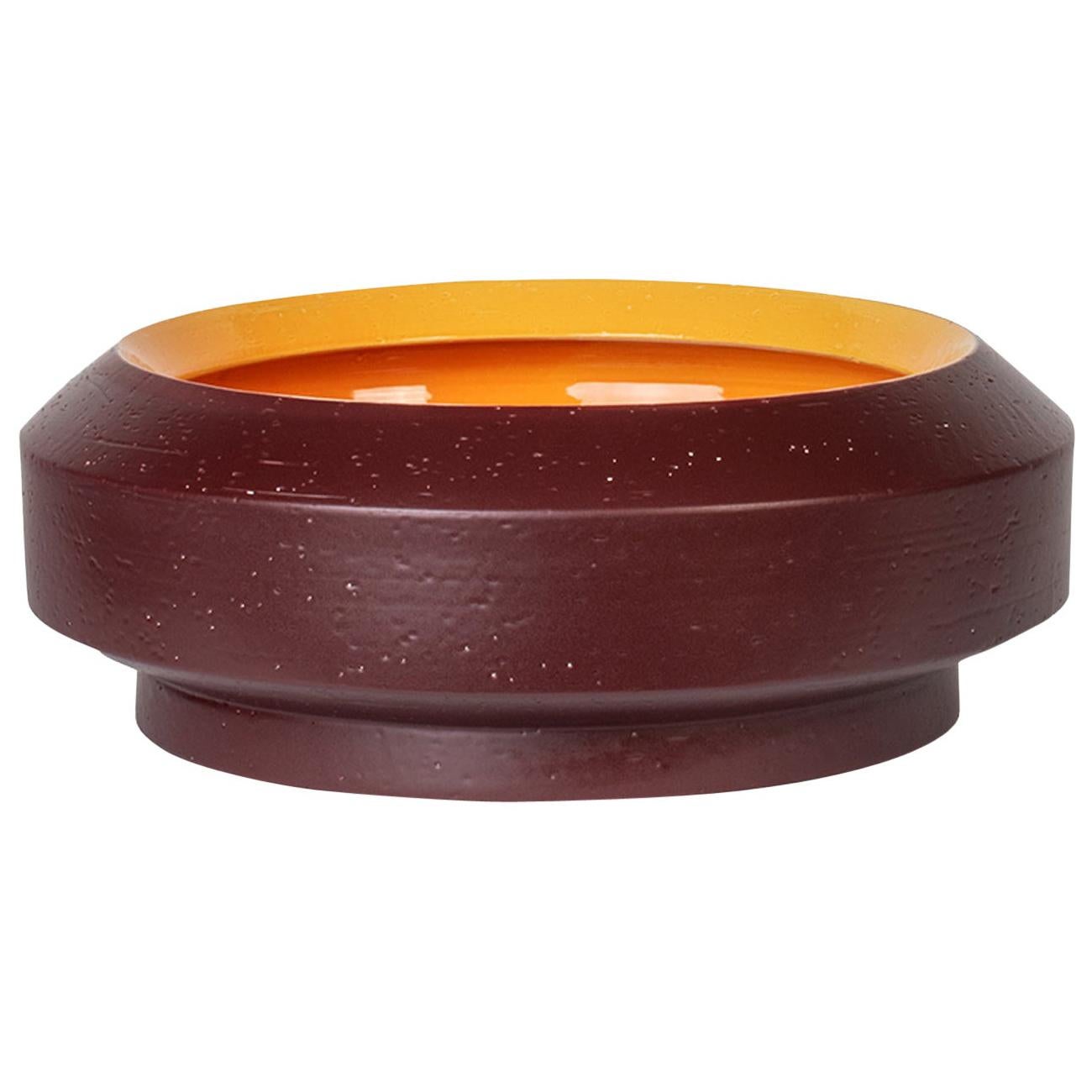 Elegant and expressive, this stylized ceramic bowl-shaped vase flaunts a two-tone finish enriching its design with earthy tones, warm brown on the outside and yellow inside, the latter visible through the wide top opening. Perfect in a modern,