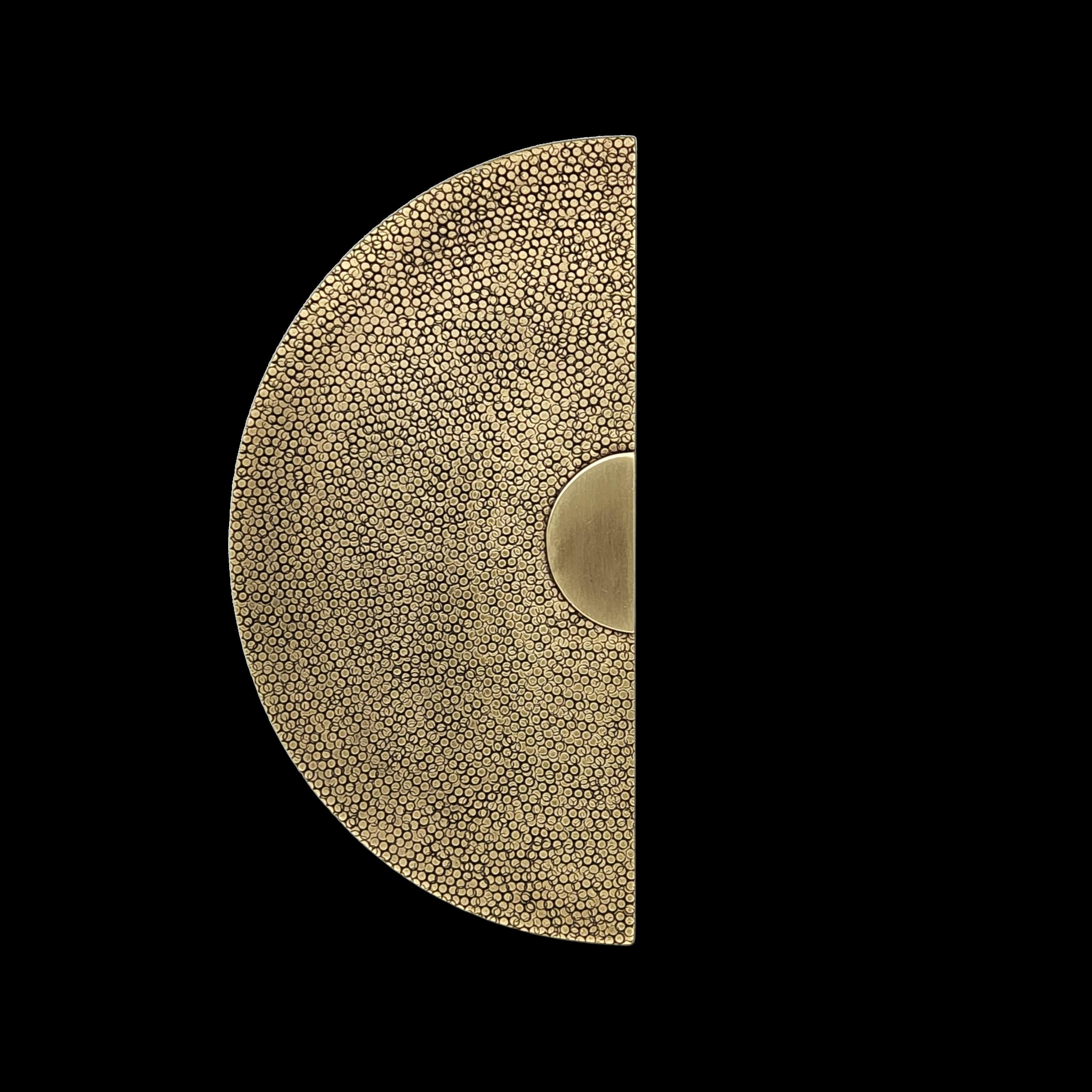 Dieser Türgriff aus massivem Messing mit seinem gehämmerten, von Zottelgrün inspirierten Muster besticht durch seine raffinierte Textur und seine sorgfältige Verarbeitung. Die mit Präzision von Hand gehämmerte Oberfläche zeigt subtile Nuancen, die