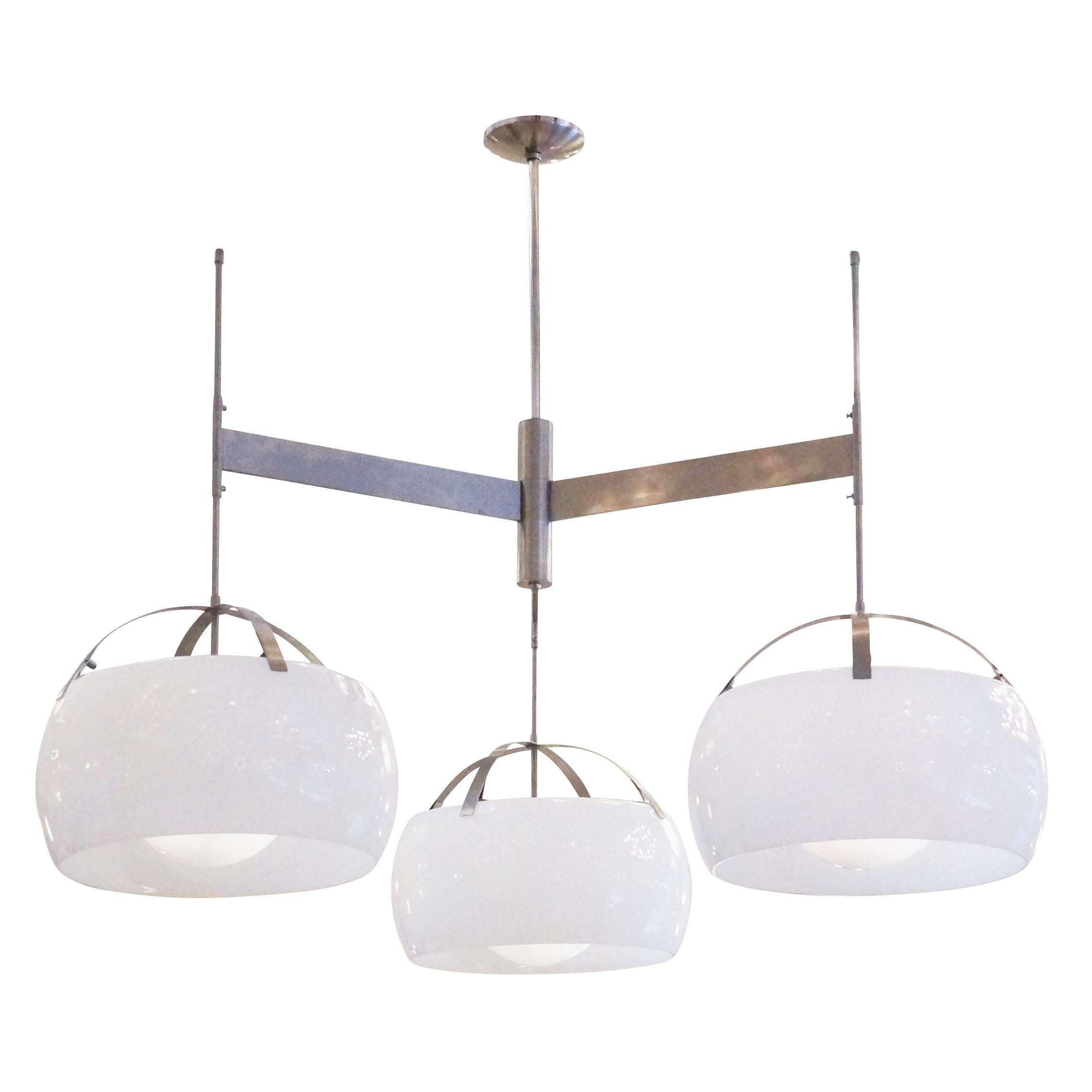 Three-light adjustable chandelier designed by Vico Magistretti for Artemide in 1961. Each satin nickel arm ends in a round glass shade covered by a secondary 