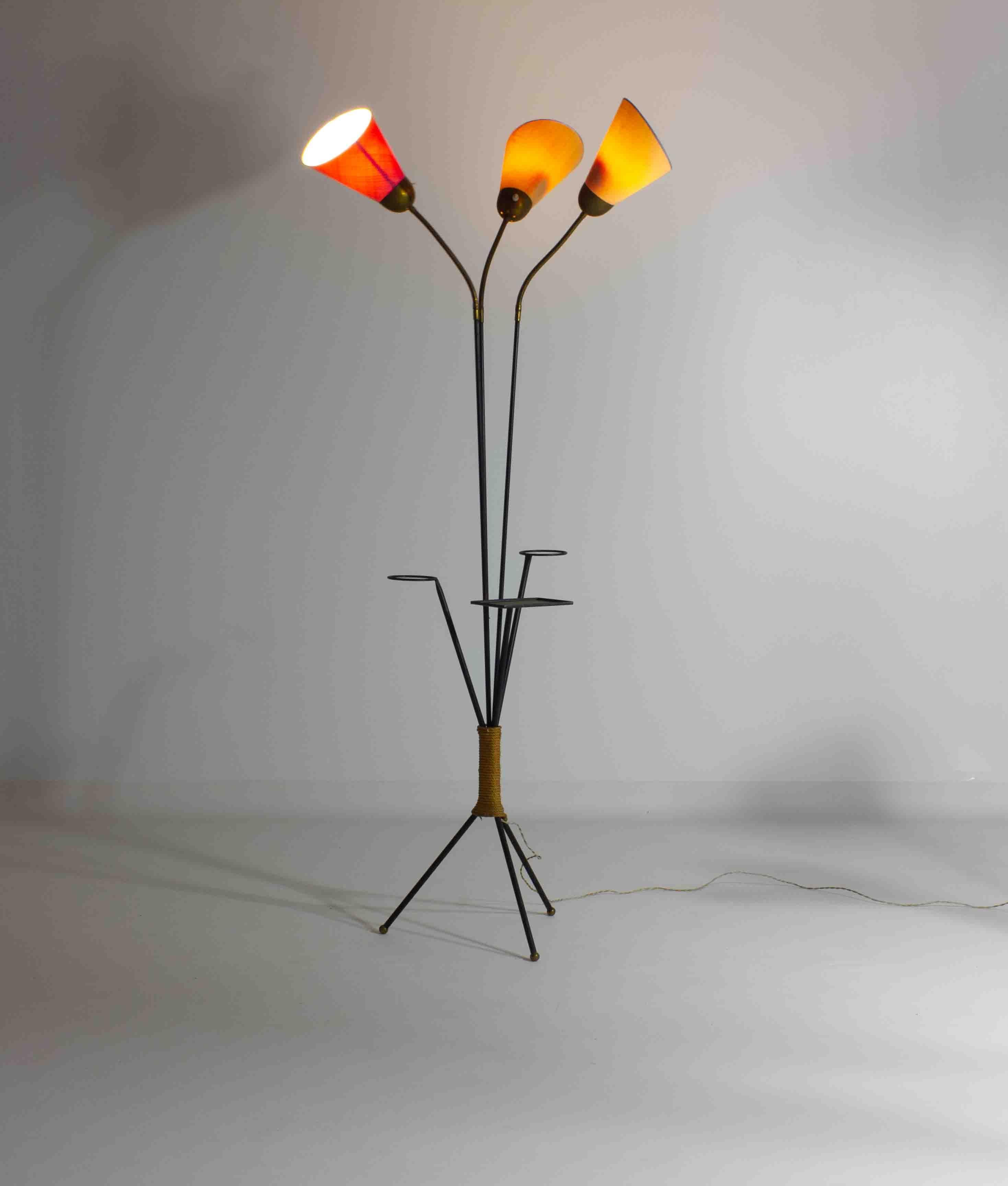 Elegant and versatile, the Fantastic Brass Three-Arm Flexible Gooseneck Floor Lamp boasts exquisite red, saffron, and ivory fabric shades. This floor lamp stands upon a sleek black iron tripod base, adorned with three modernist brass ball feet. A