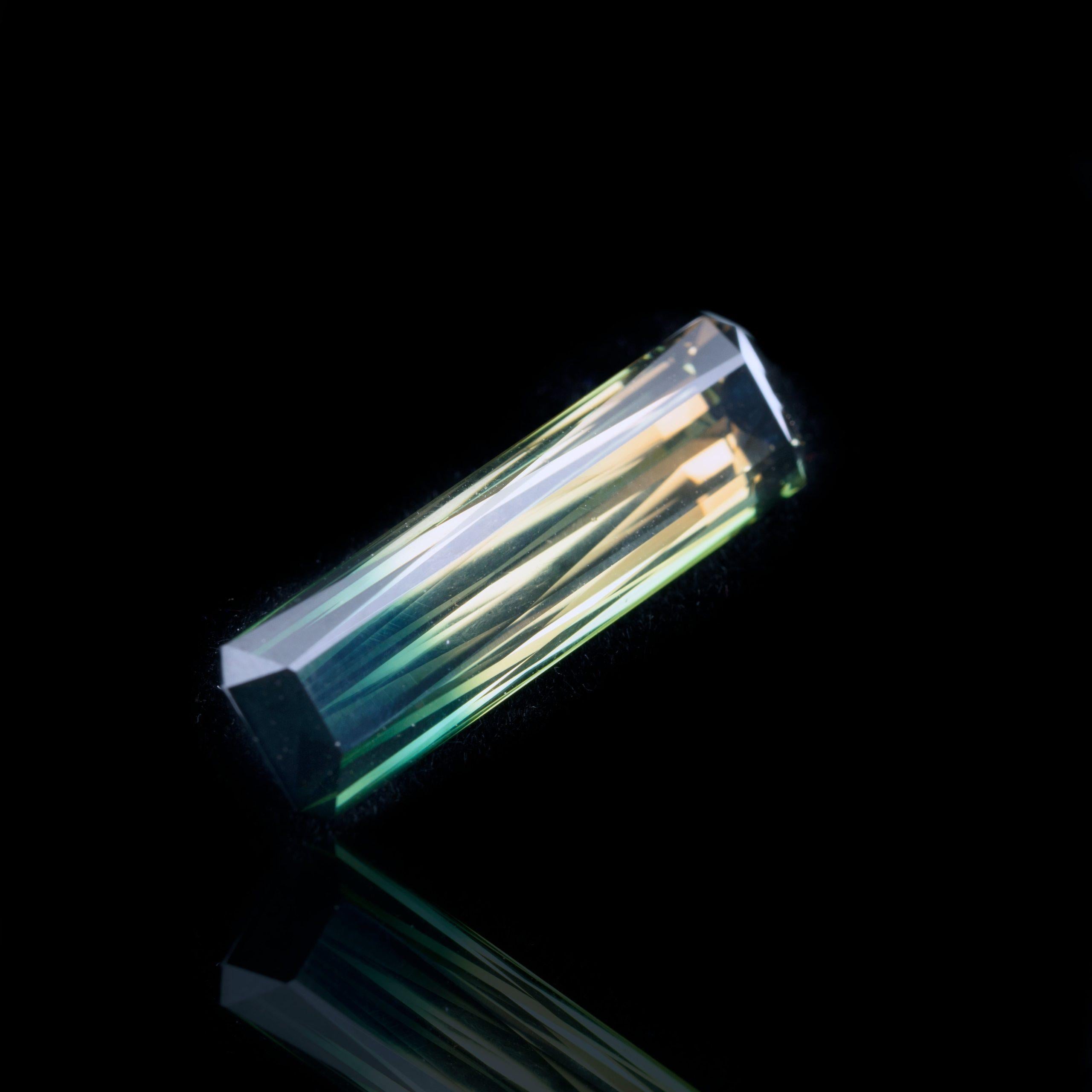 Ce spécimen de tourmaline bicolore du Brésil, parfaitement facetté et poli, présente des teintes allant du vert profond au bleu, puis à un rare jaune chromé, ainsi qu'une incroyable clarté. La tourmaline tricolore est une variété d'elbaïte très