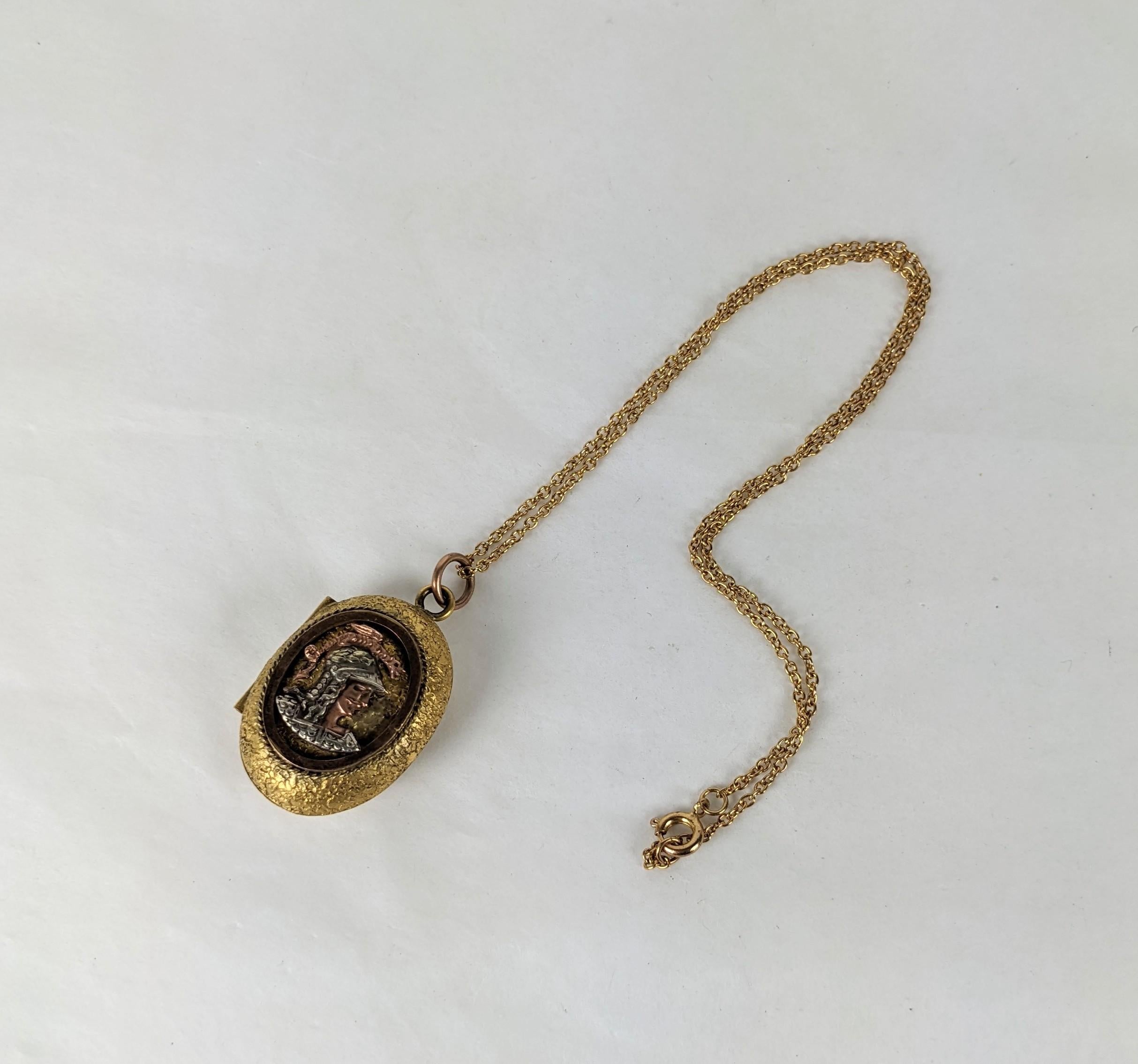 Unusual Tricolor Victorian Locket of a warrior rendered in 3 tones of gold on a gold filled base. A warrior is depicted in profile on the front with a hammered gold back. Glass interior intact, but chain is not original. 1 3/8