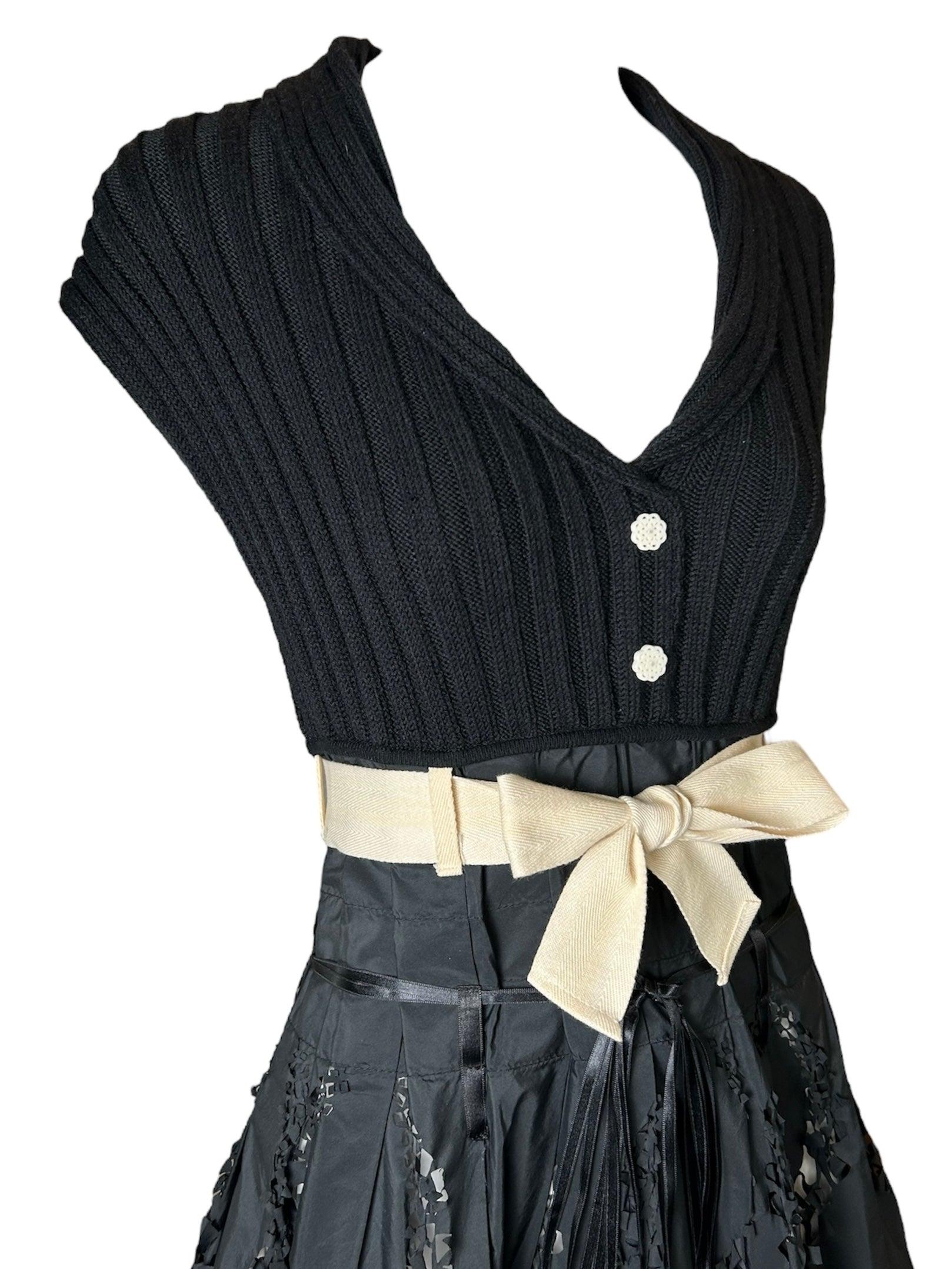 Profitez d'un mélange parfait de féminité et d'avant-garde avec notre robe à jupe complète avec nœud en Tricot Chic 2000's Laser-Cut. Cette superbe création fait un clin d'œil à la coupe cintrée des années 50, soulignée par un délicat nœud de taille