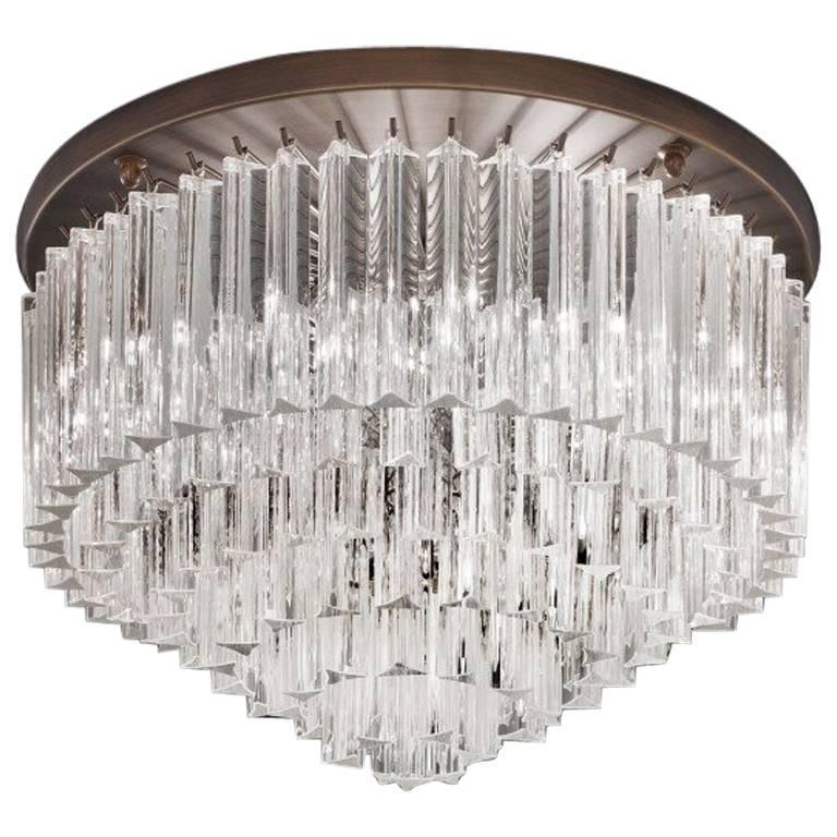 Italian flush mount or chandelier with clear Murano glasses cut in Triedri technique arranged in layers on bronze finish metal frame by Fabio Ltd / Inspired by Venini / Made in Italy
6 lights / E12 or E14 type / max 40W each
Diameter: 20 inches /
