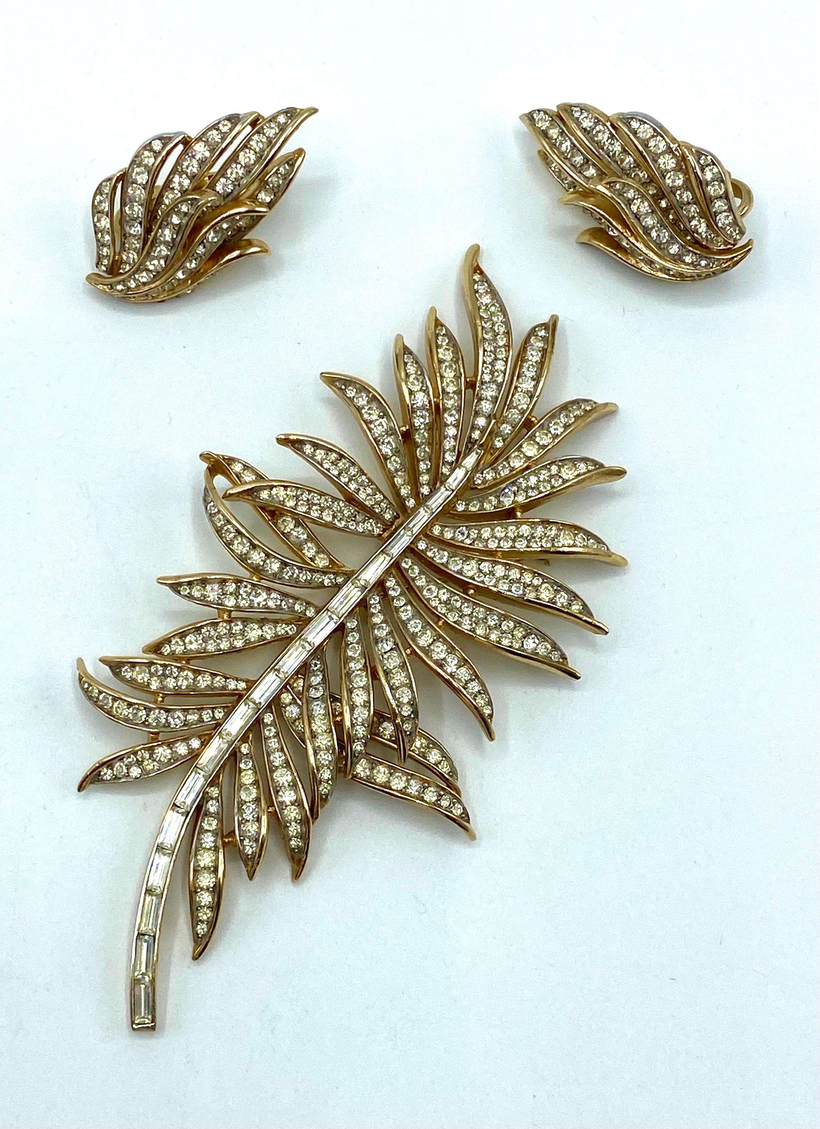 A beautiful and in excellent condition Trifari rhinestone leaf brooch and earring set. Gold and rhodium plated and set with rhinestone baguettes along the spine and round rhinestones on the leaves. The rhodium plating is inside the eaves where the