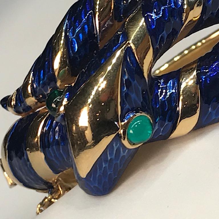 Trifari 1960s snake bangle beautifully enameled in a royal navy blue. Eyes are set with green glass cabochons. Shiny gold exterior and textured satin gold interior. Push pin clasp with original safety chain. Interior circumference when closed is 6.5