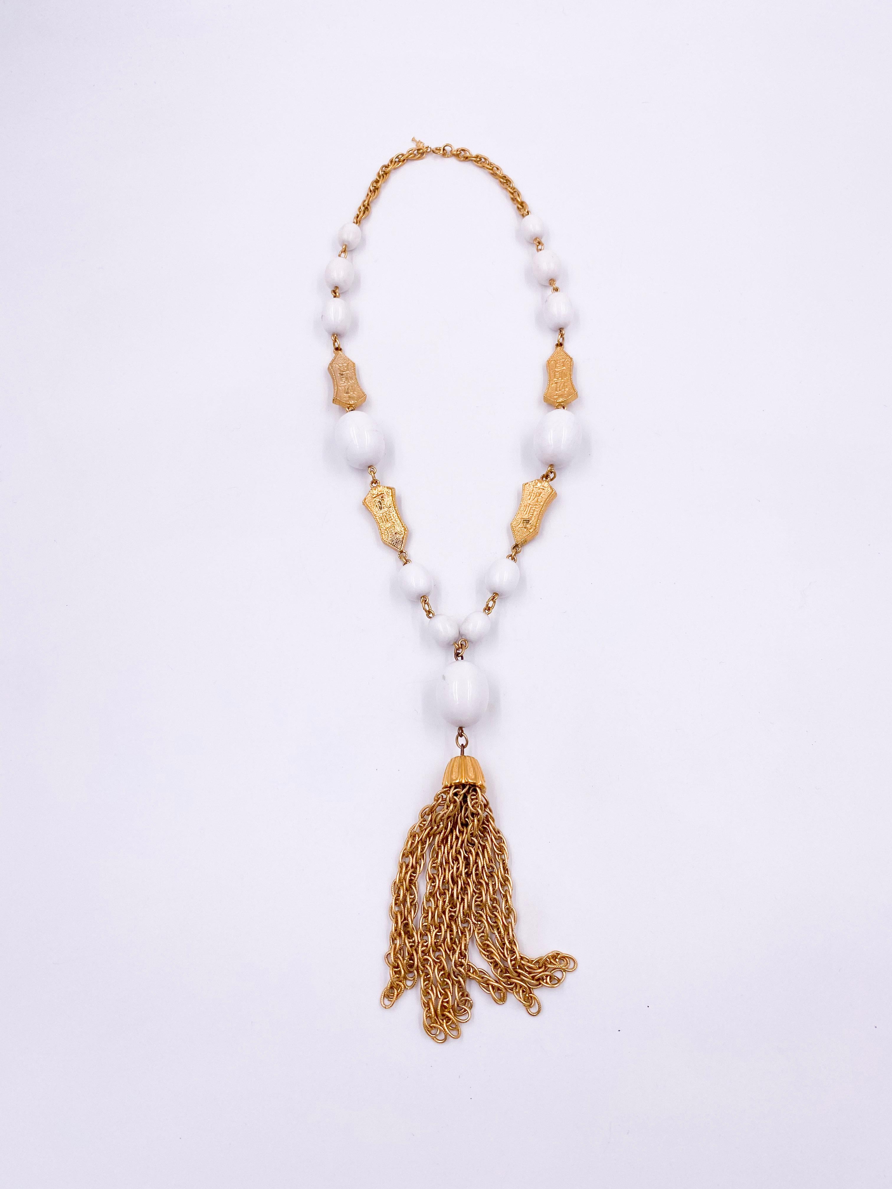 Elevate your ensemble with the Trifari White Ball and Gold Tassel Crown Necklace, a timeless piece featuring lustrous white beads accented by elegant gold details. Its versatile design allows for layering, making it an ideal accessory for weddings