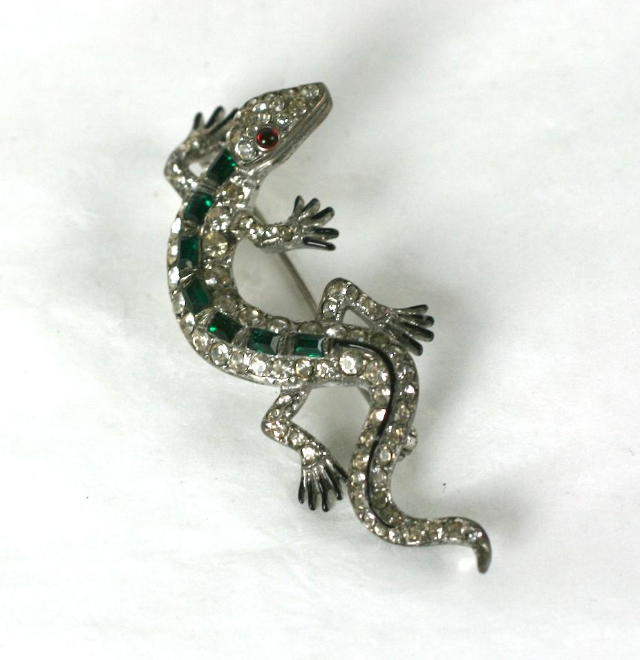 Charming Trifari Alfred  Philippe Art Deco faux emerald baguette and crystal rhinestone lizard brooch. Of rhodium plated sterling silver with the cocked head accented with a faux ruby cabochon eye. Marked Trifari with crown and Sterling .
Excellent
