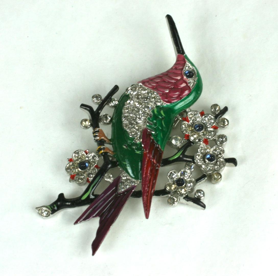 Rare Alfred Philippe for Trifari brooch of an exotic humming bird perched on a branch of Japanese cherry blossoms. Deftly cold enameled in shades dark pinks, purples and emerald greens. The deep brown branches cherry blossoms of round crystal