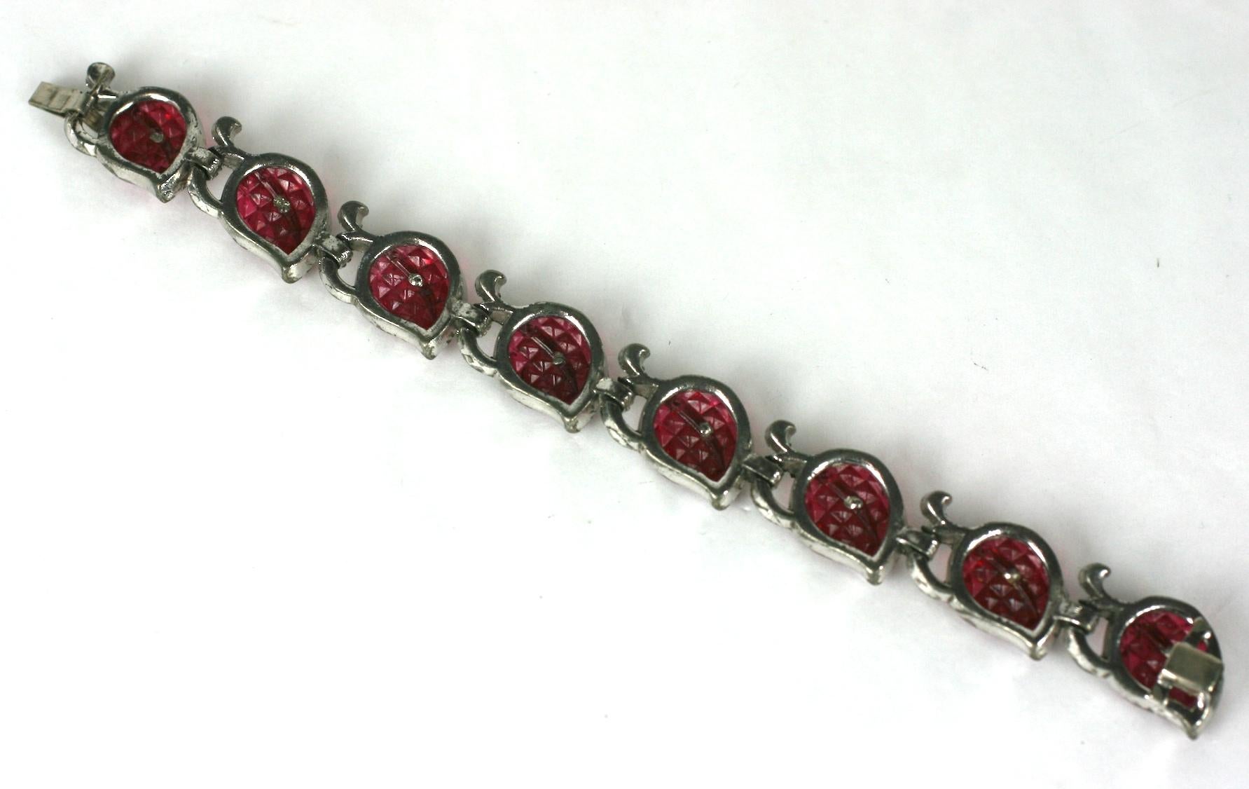Trifari Alfred Philippe Invisibly set KTF ruby leaf Art Deco bracelet. The articulated links composed of eight invisibly set faux ruby glass leaves with crystal pave set in rhodium plated base metal.
This bracelet is  characteristic of patented KTF